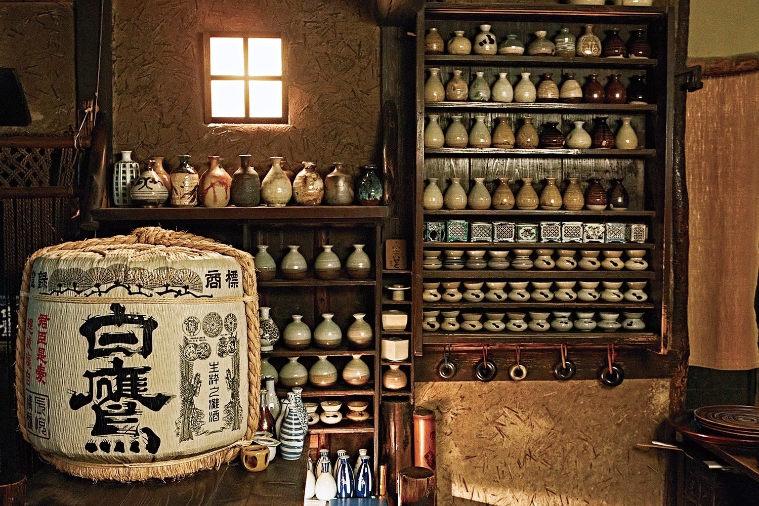 ●「伊勢藤」の浅棚にならぶ白徳利と清酒・白鷹の薦被り四斗