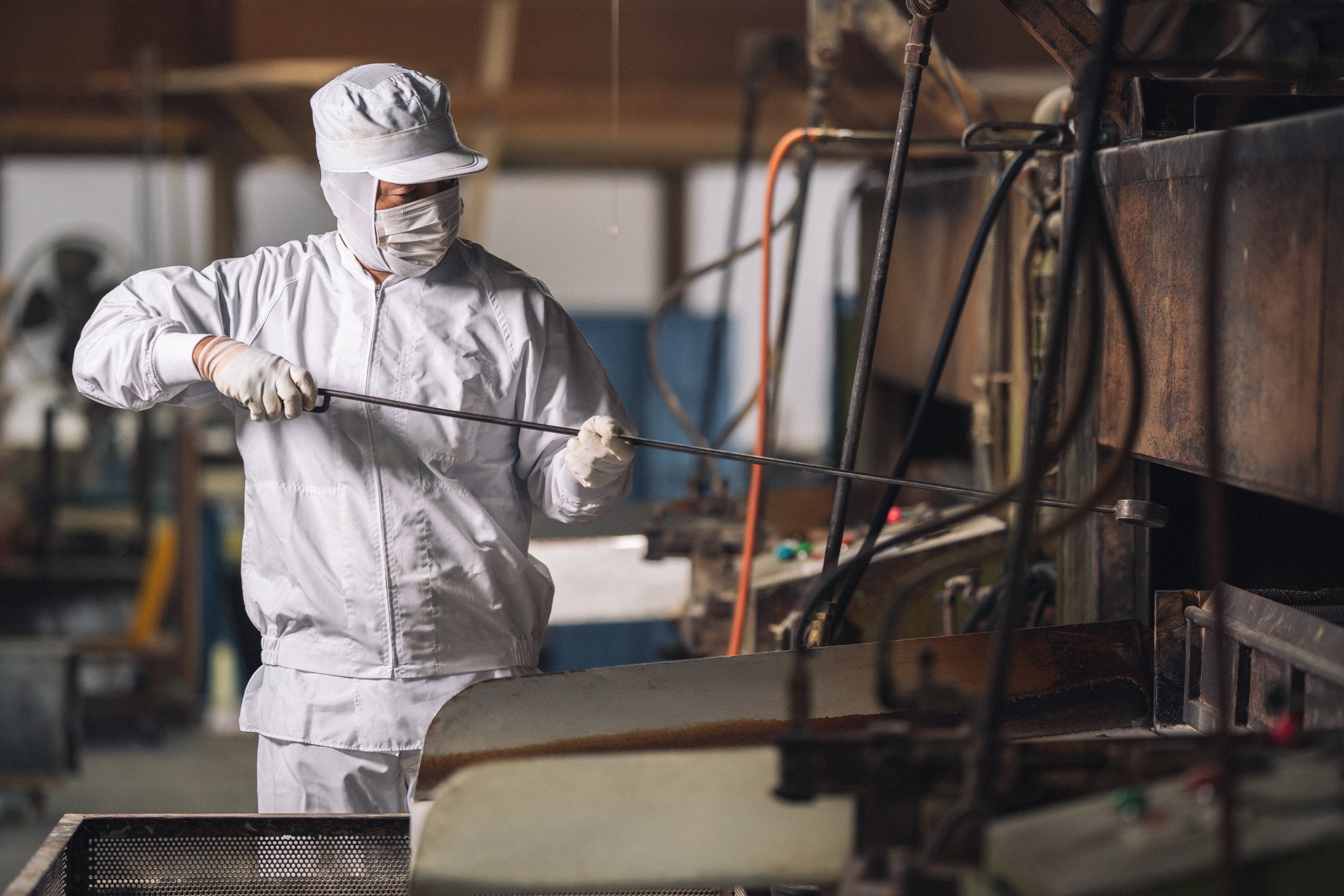 冨士屋製菓本舗の豆菓子を作る際のガスの直火で生地を付けた豆に火を入れえる「煎り」