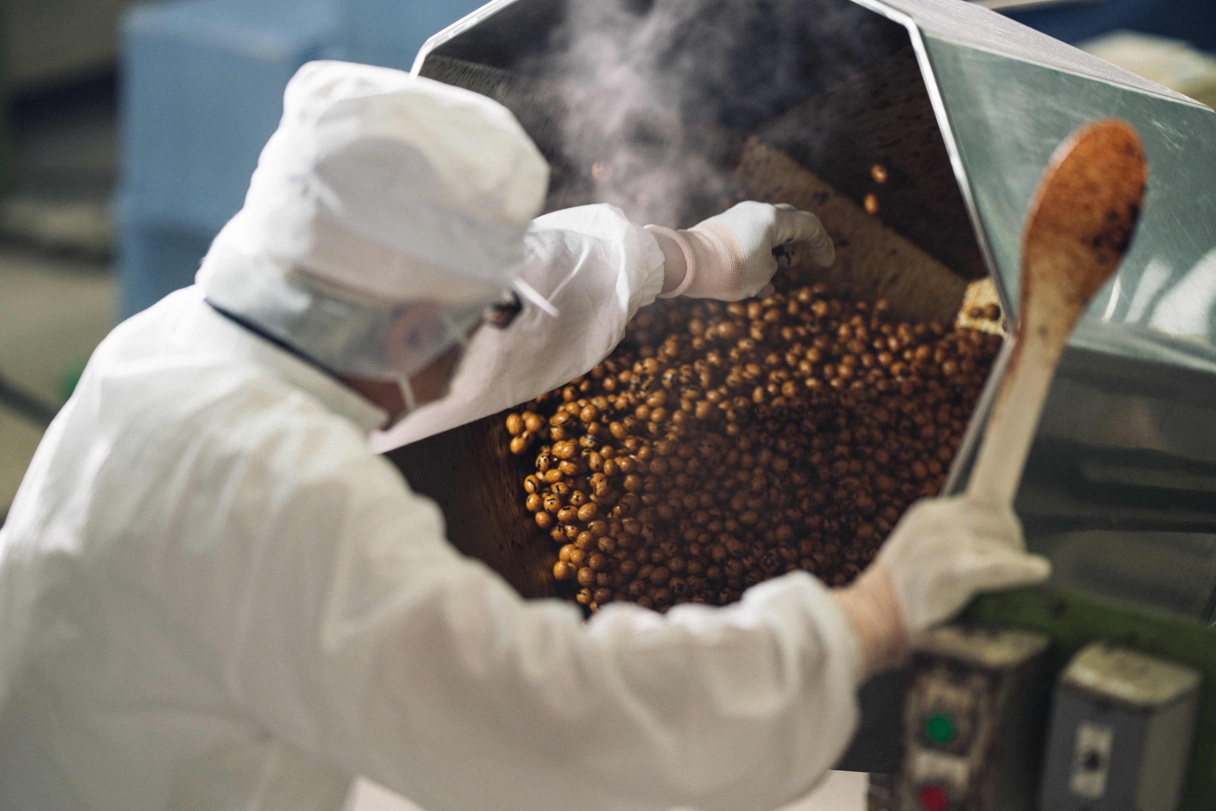冨士屋製菓本舗の豆菓子を作る際の味付けで醤油をかける作業の様子