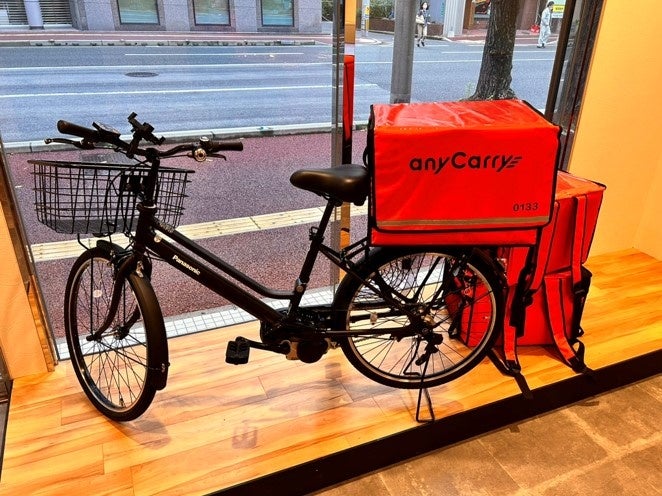 九州支社入口のディスプレイ（自転車と配送バッグ）