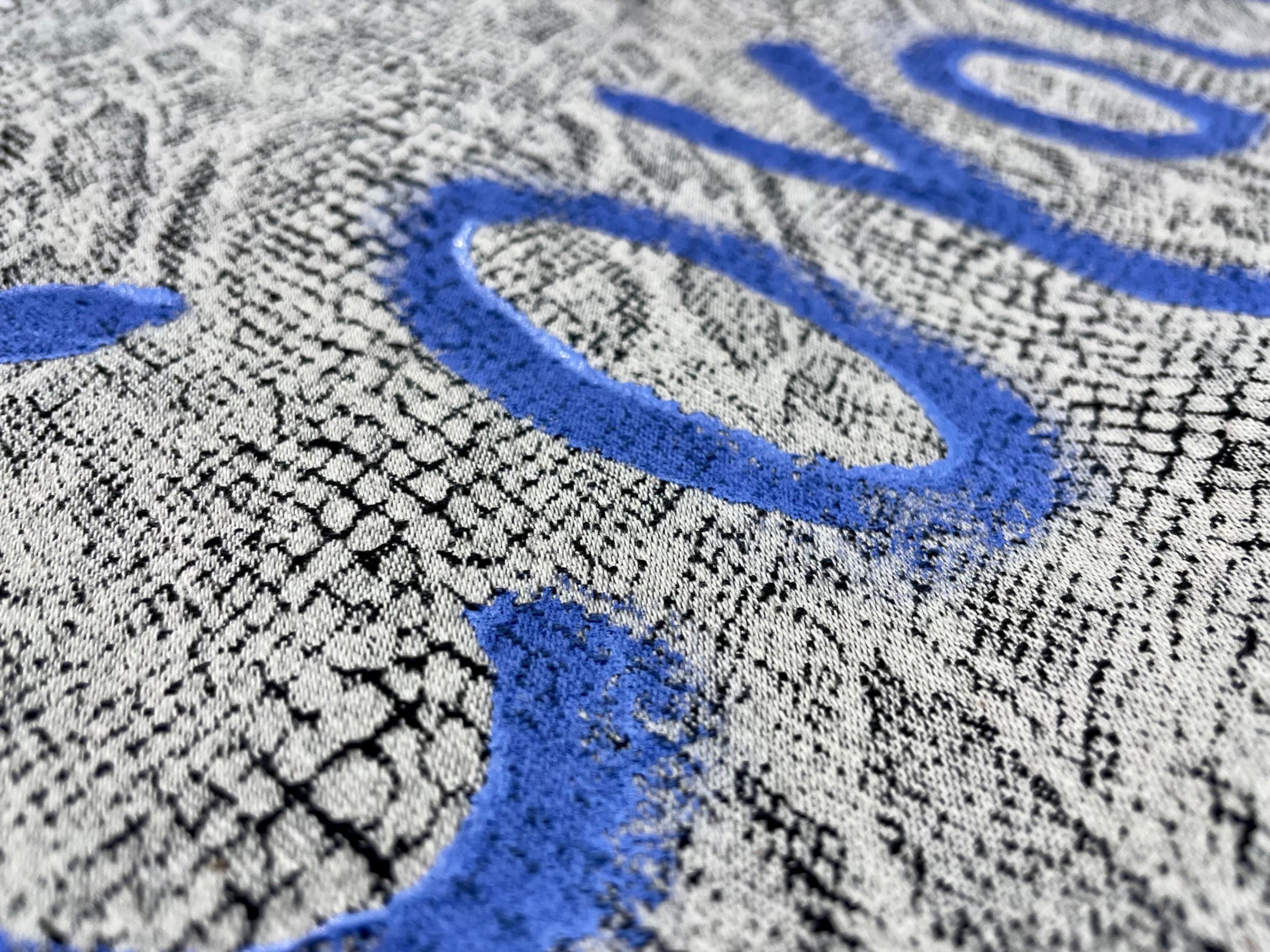 ジャガード織のデニムに施されたハンドペイント