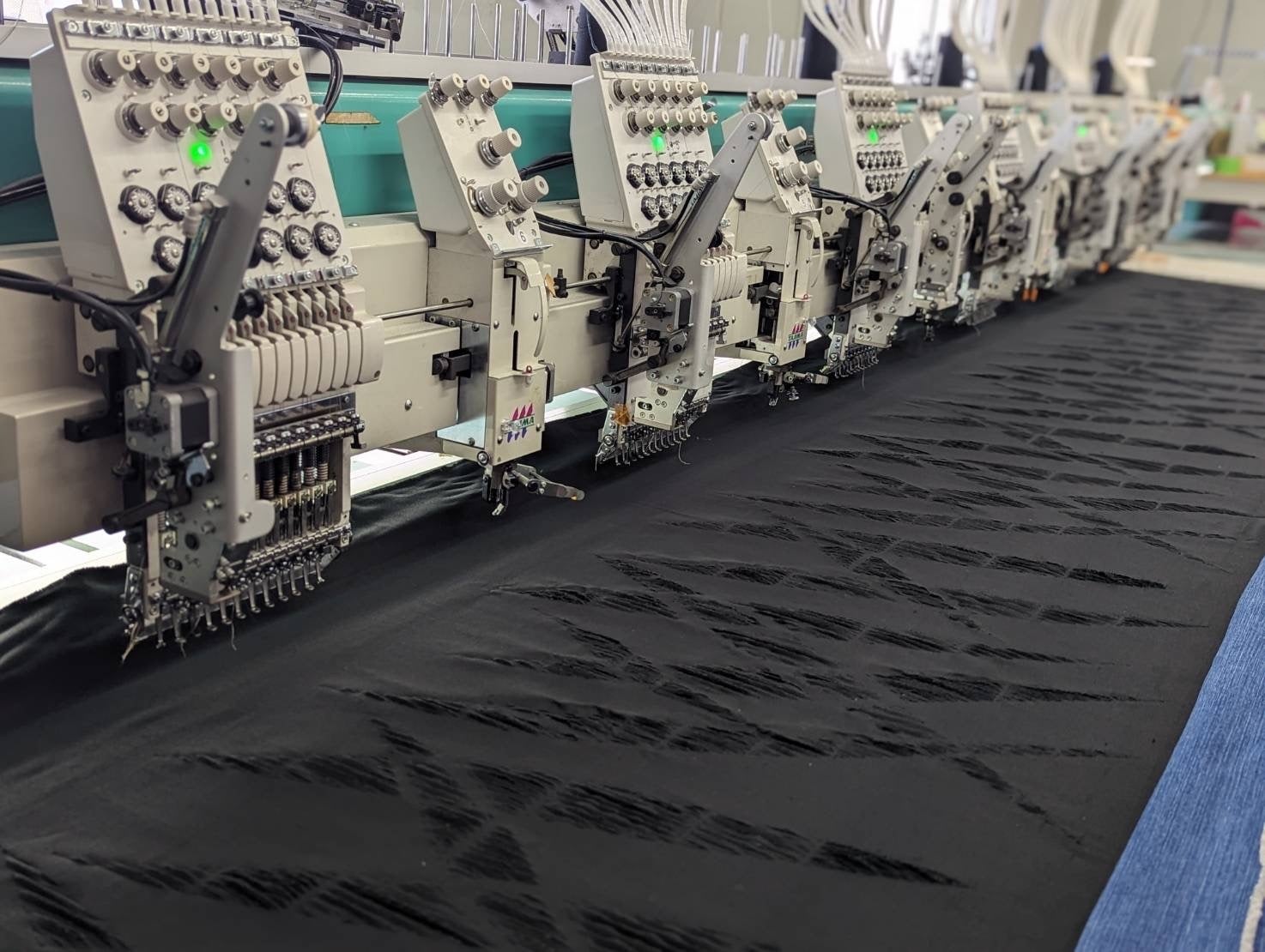 ダメージを施しながら刺繍糸で2種のデニムを繋ぎ合わせる特殊素材の制作工程。