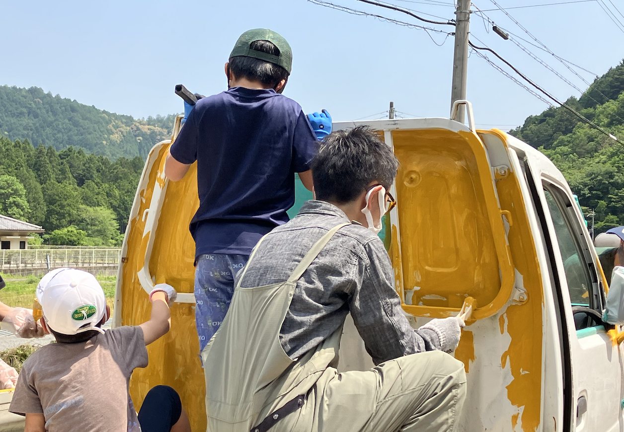 リターンイベントにて軽トラを塗装する市川と参加者