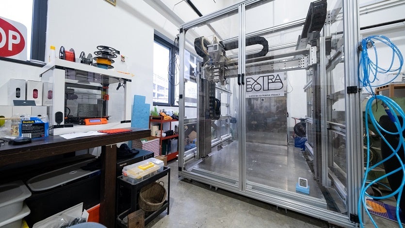 シンガポールの子会社に設置した、大型3Dプリンター試作零号機「EXF-10」と作業スペースの様子