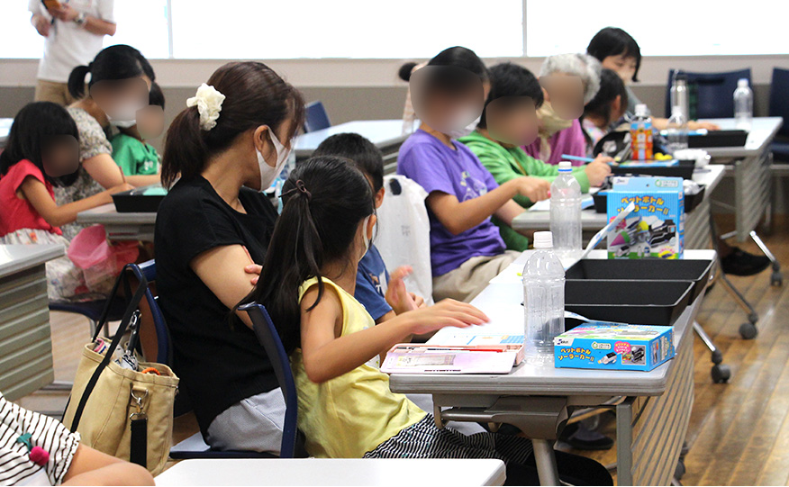 メモを取りながら講義を聞く子供たち