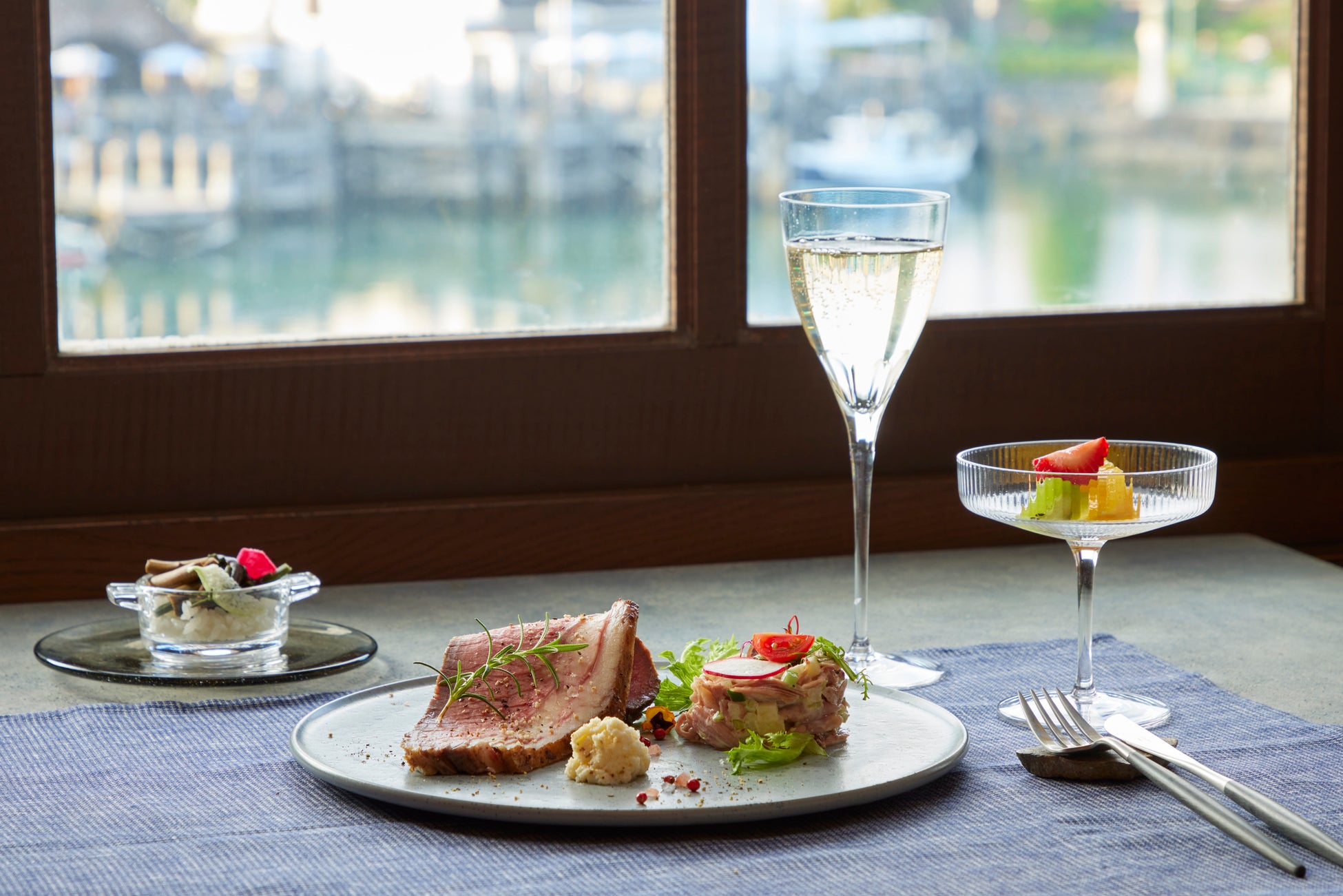 窓越しに望む景色と料理(イメージ)