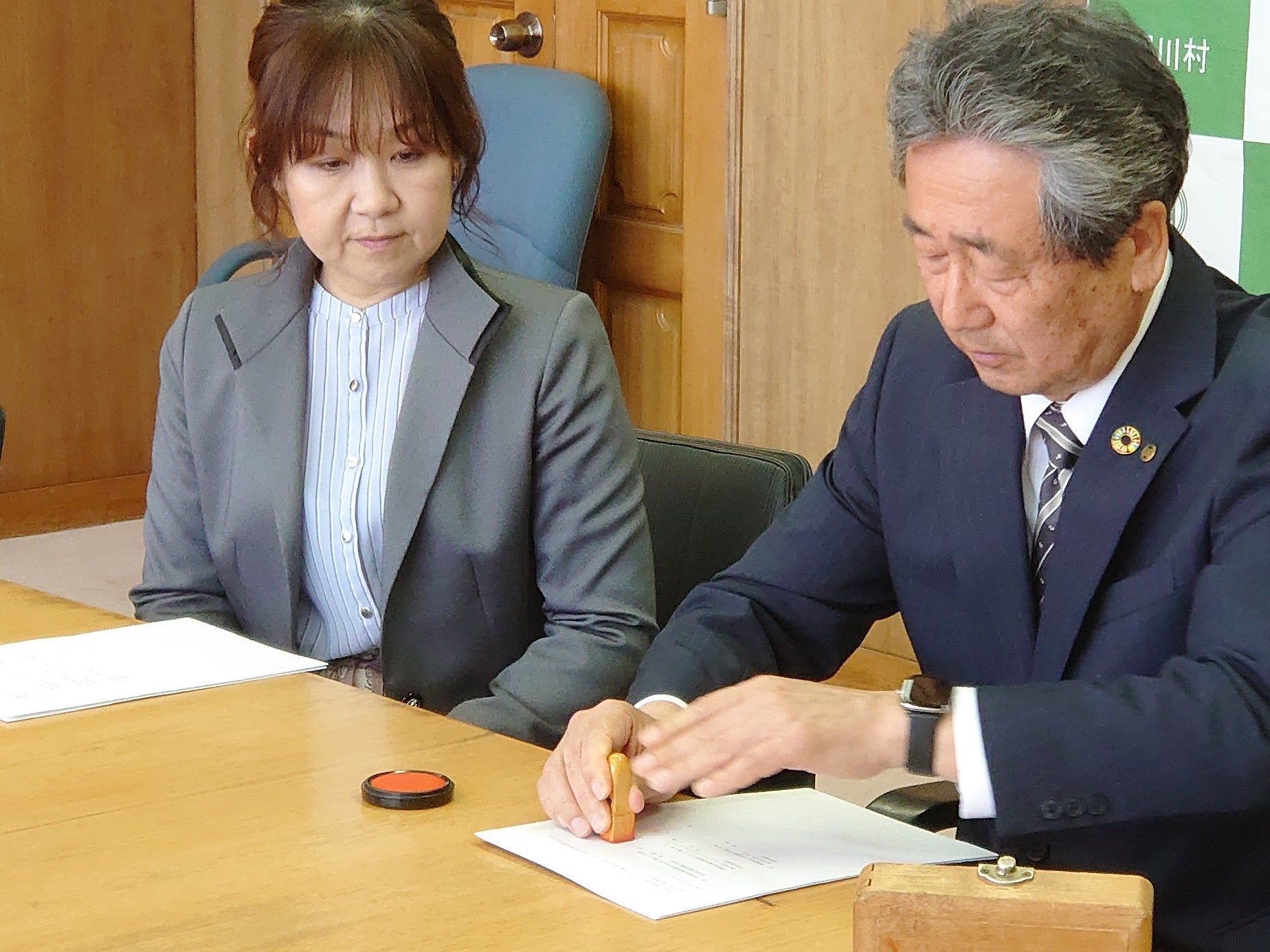 協定締結式の様子（左：株式会社あいをん 代表取締役 魚野ルミ／右：関川村 村長 加藤弘）