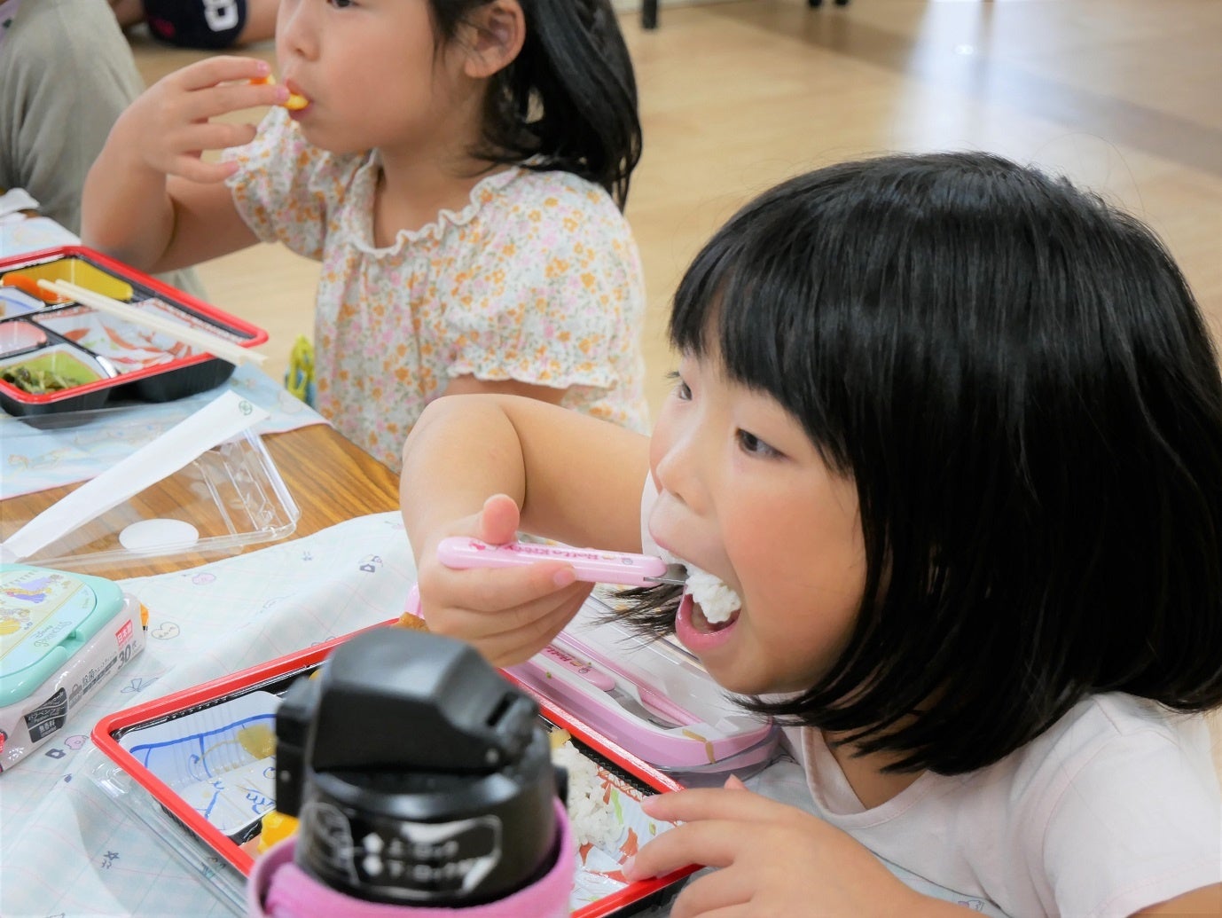 大きな口を開けてご飯を頬張る児童
