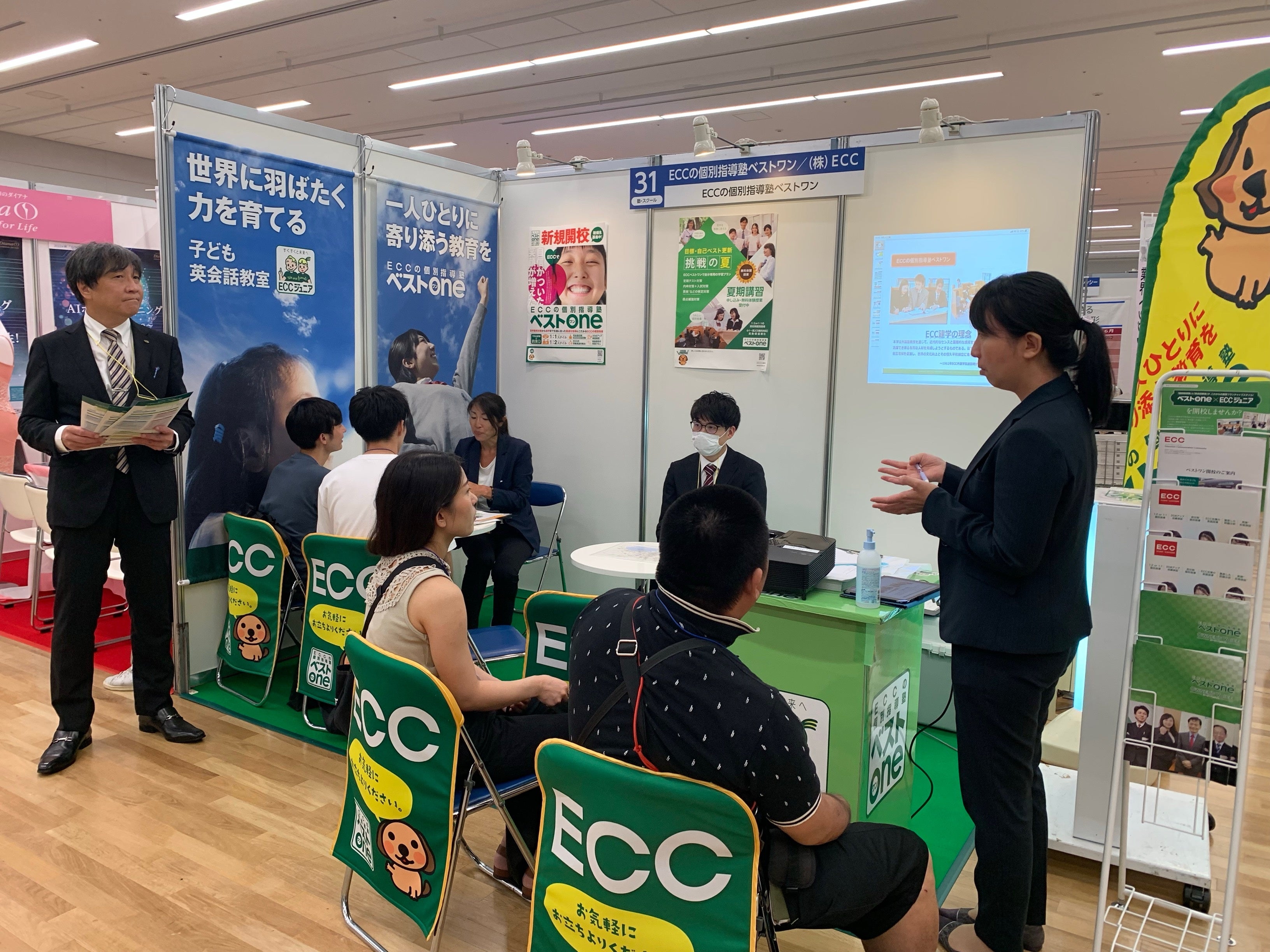 学習塾事業について紹介する出展企業（株式会社ＥＣＣ）と説明を聞く来場者