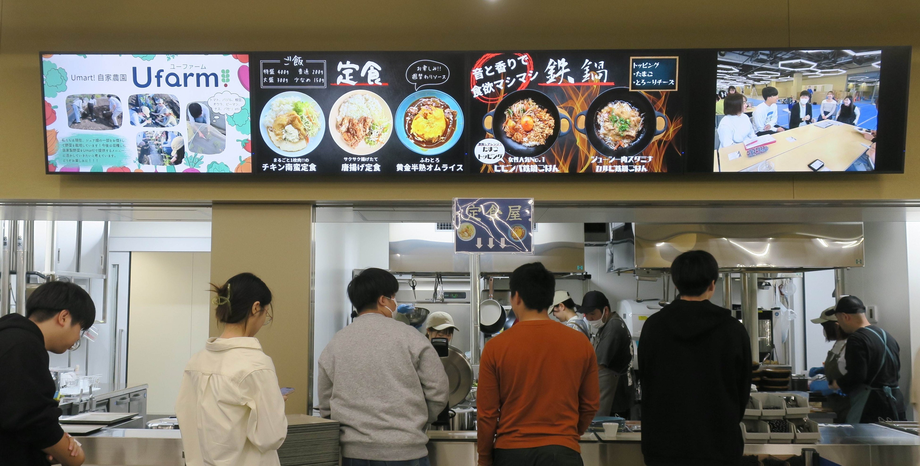 食事をする学生が、調理をしている同じ学生からもてなしを受ける