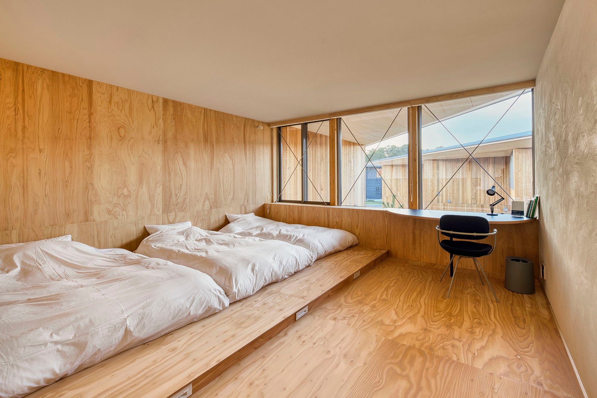 ダブルベッド1台、シングルベッド2台、ワークスペースにはbooks+kotobanoieの加藤博久氏が選書した本が並ぶ