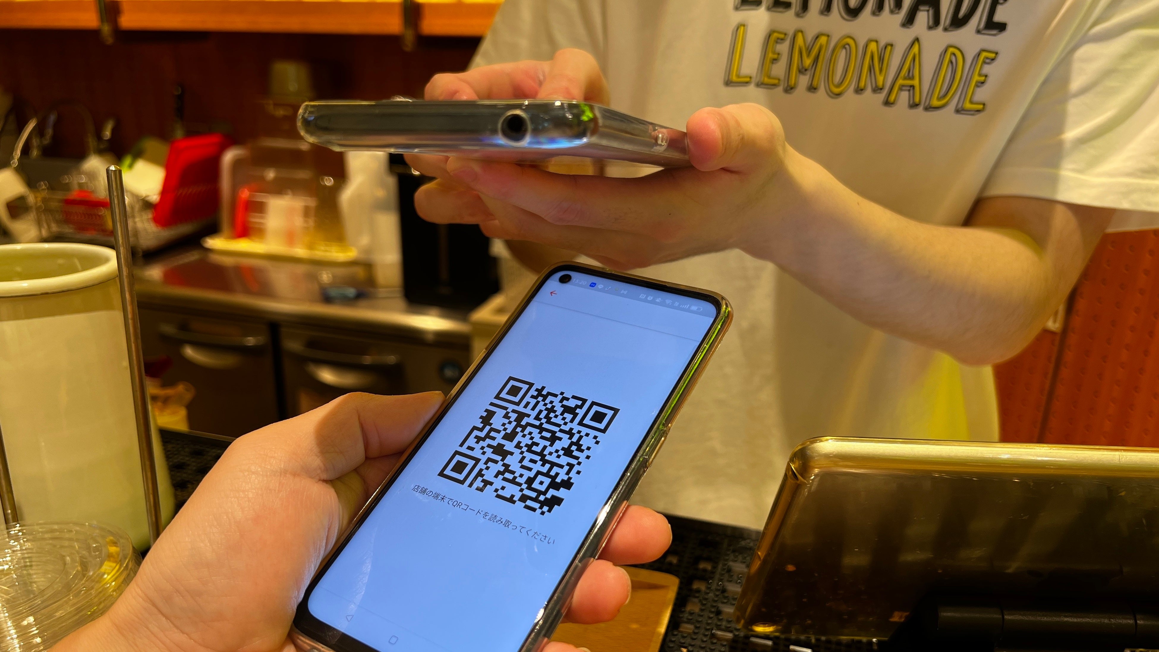 お客様側アプリのQRコードを店舗側が読み取り、決済を紐づける様子