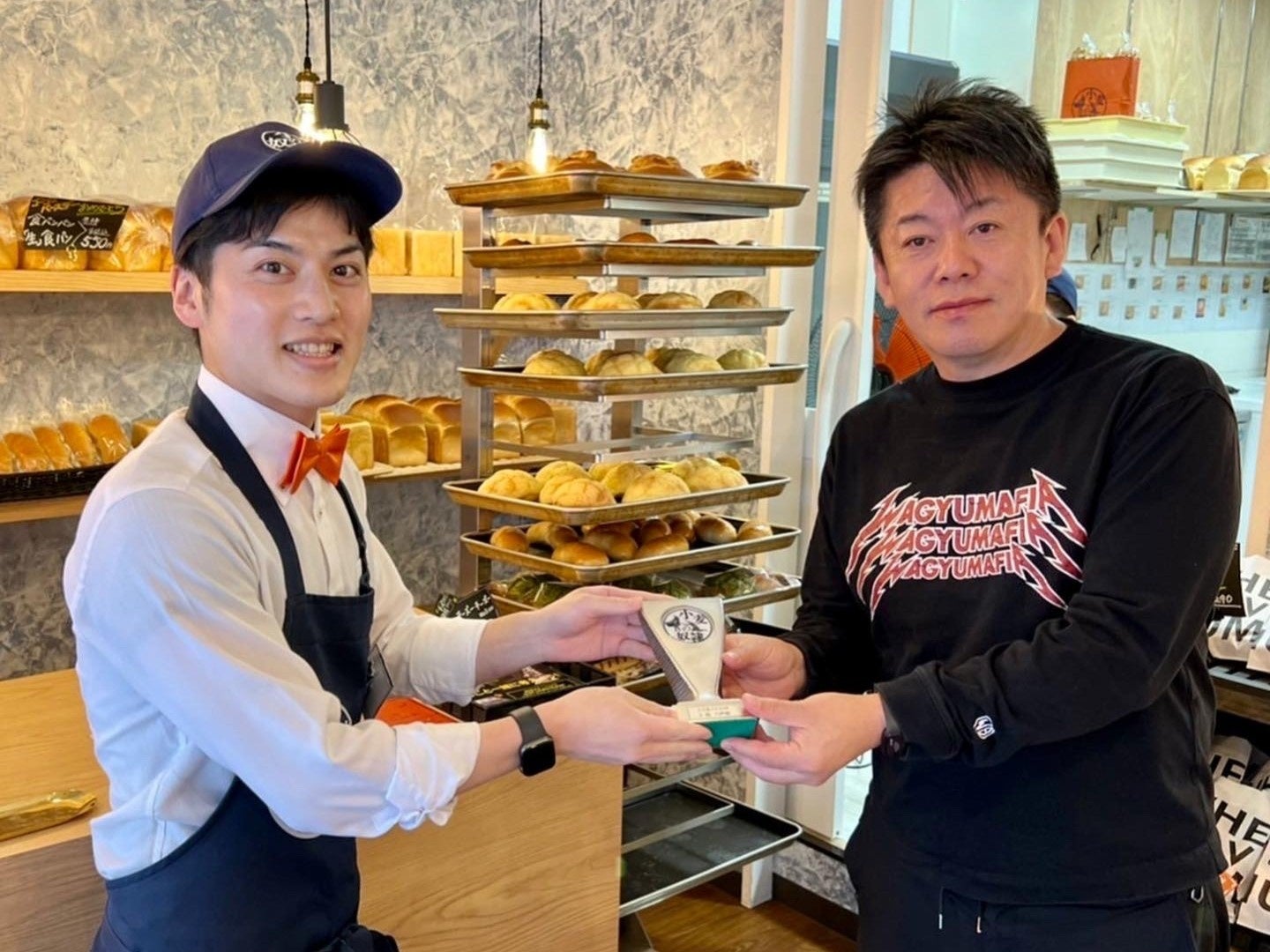 オープン2周年を迎える小麦の奴隷 八戸店 店長ミュート（左） ブランド発案者の堀江 貴文（左）