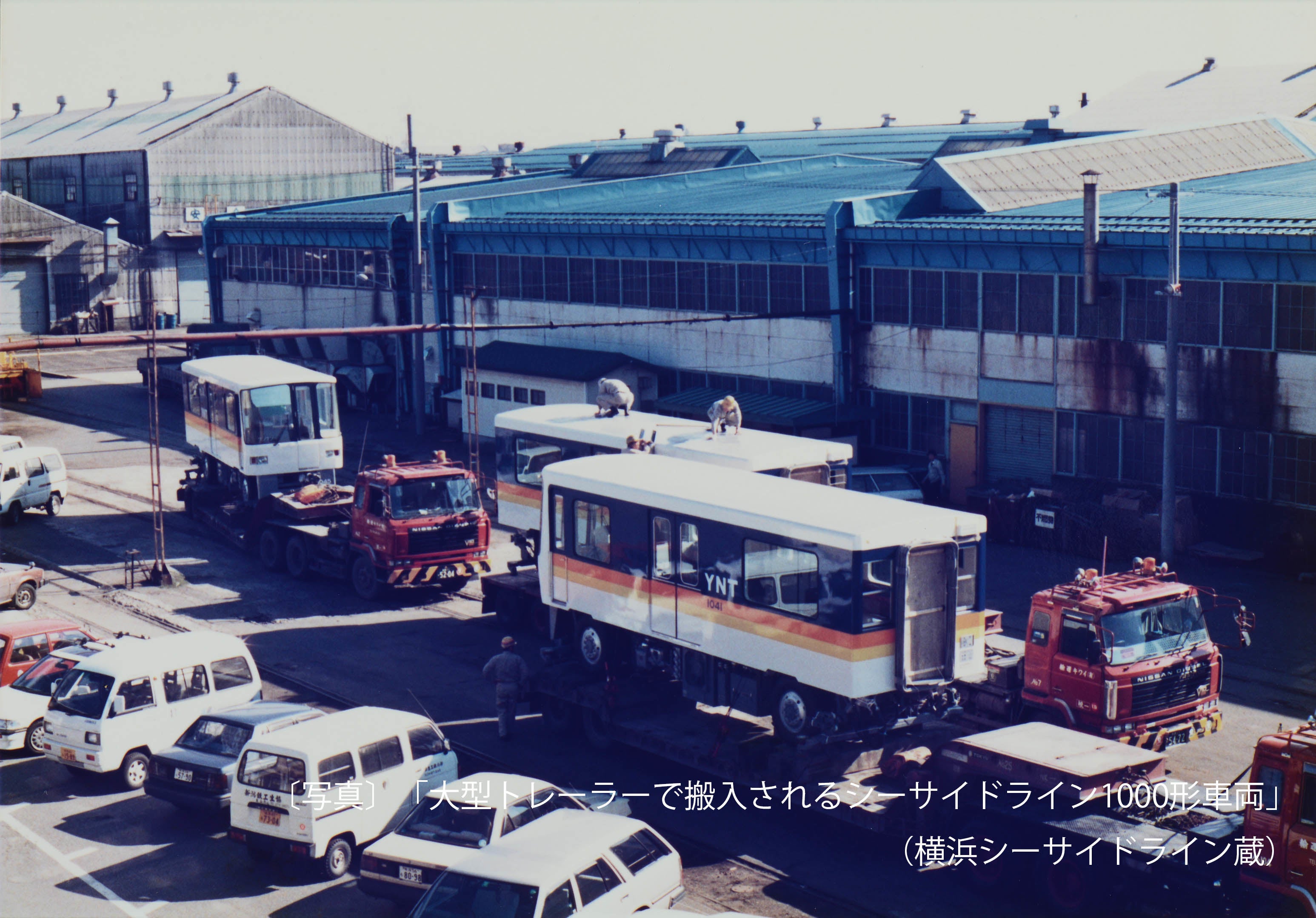 〔写真〕「大型トレーラーで搬入されるシーサイドライン1000形車両」（横浜シーサイドライン蔵）