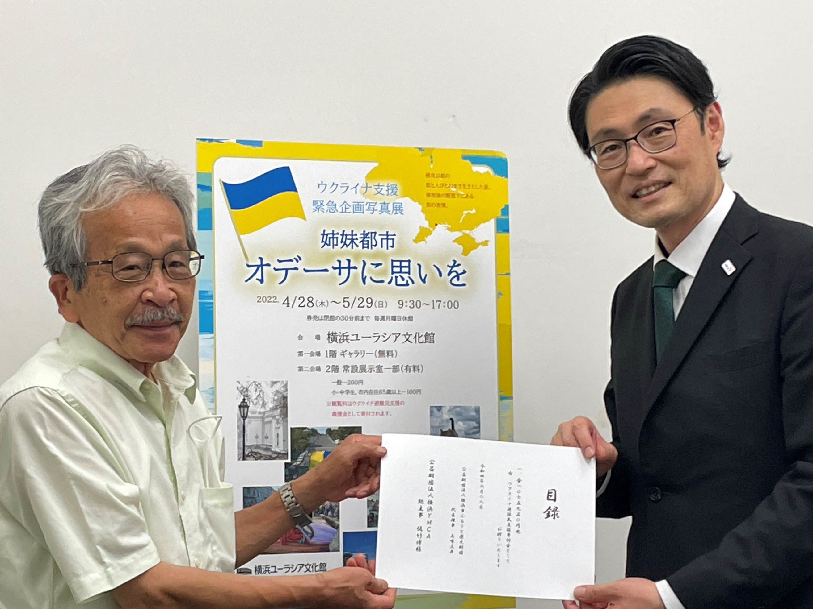 寄付金の目録贈呈（左：横浜ユーラシア文化館館長　上山 和雄氏、右：横浜YMCA総主事　佐竹　博氏）