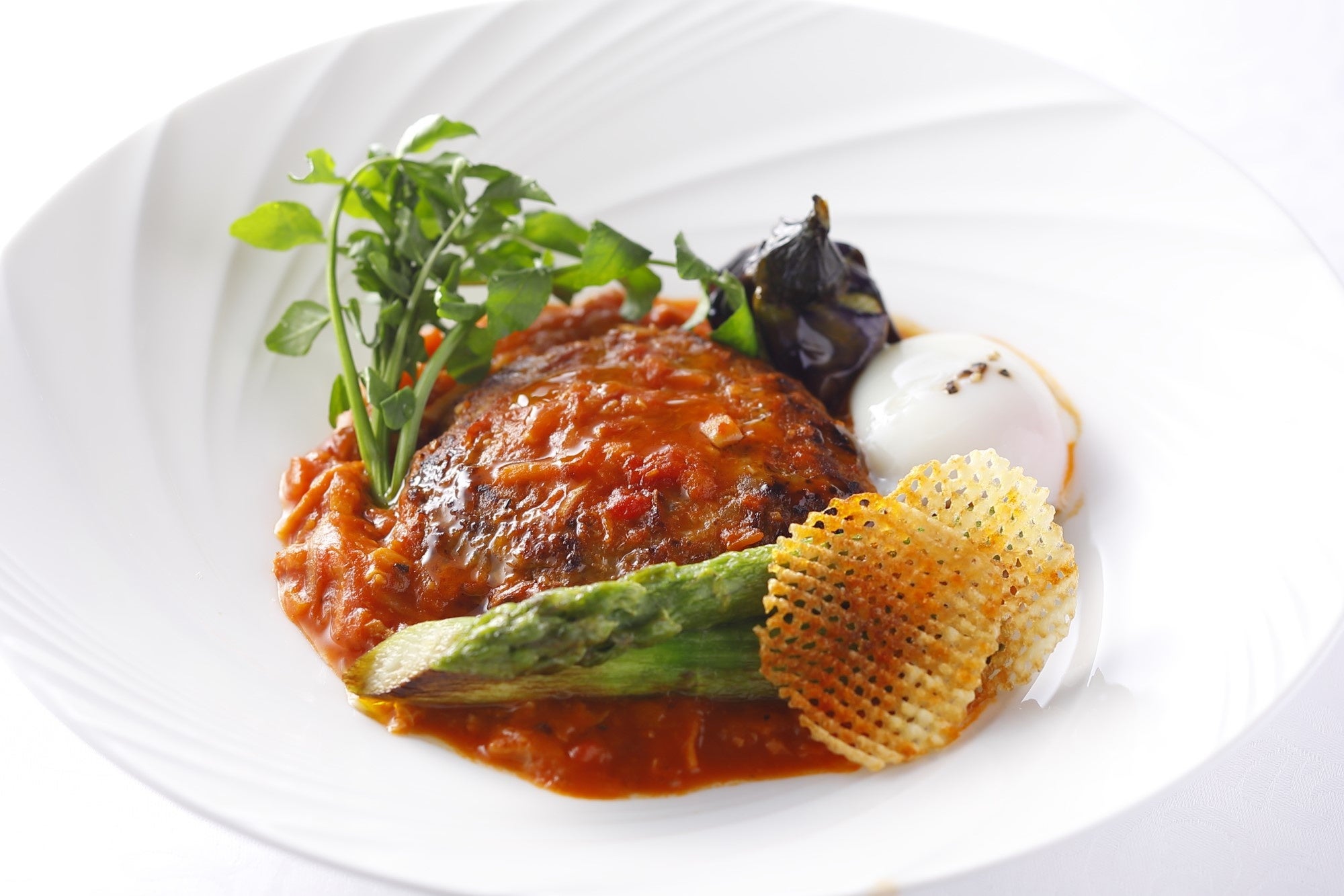 トマトソースでやわらかく煮込んだハンバーグとトリッパ　温度卵添え