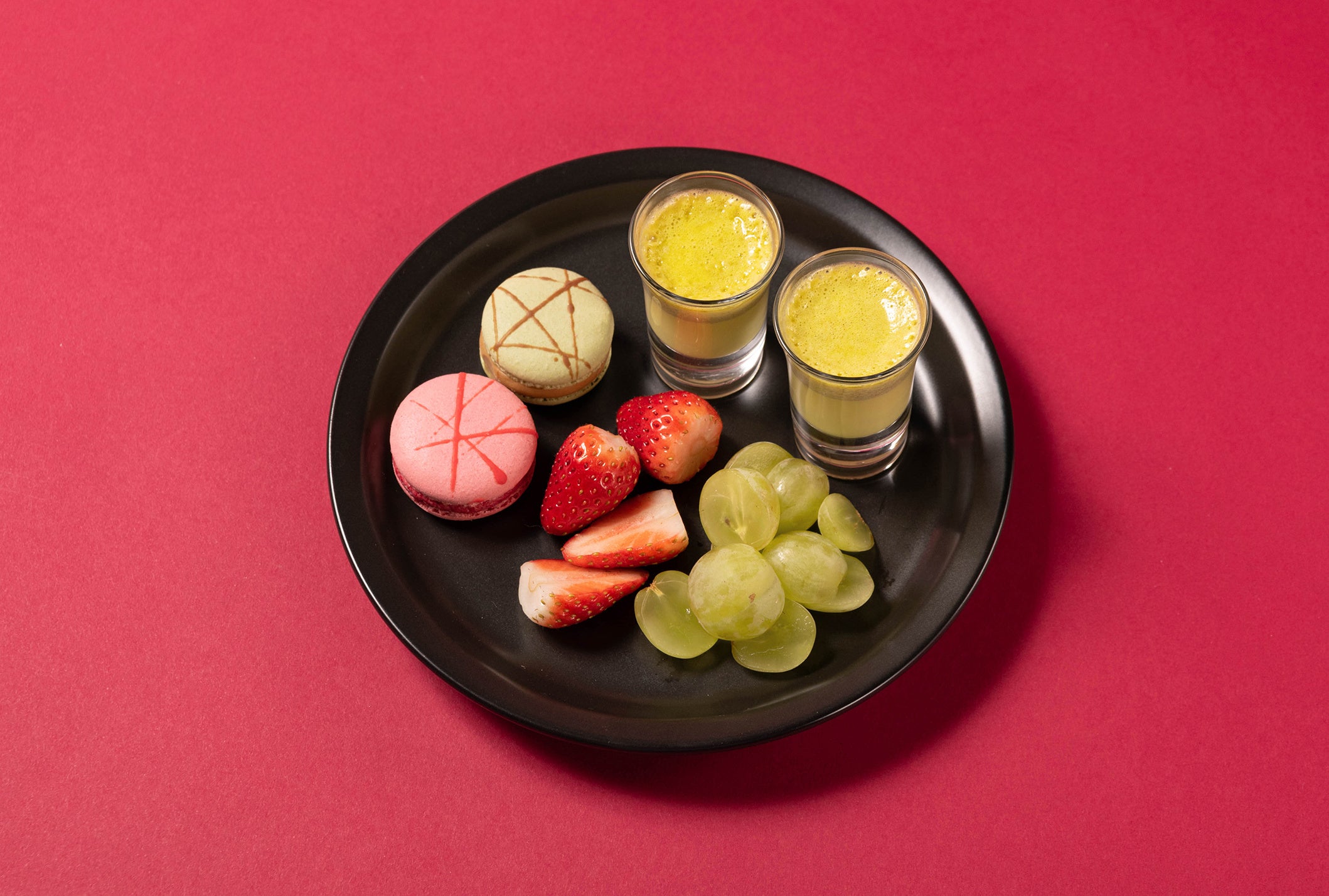 二段目： 濃厚な味わいの自家製ピスタチオプリン、アールグレイ& ラズベリーのマカロン、フレッシュなイチゴと白ブドウ。