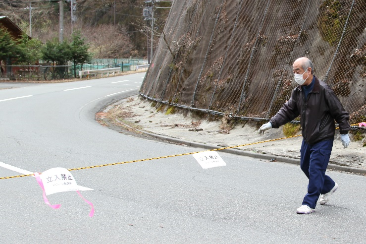 ▲ドローン飛行の安全上、着陸地点半径30m以内に 人が立ち入らないよう、規制線のロープを張る中津川区長