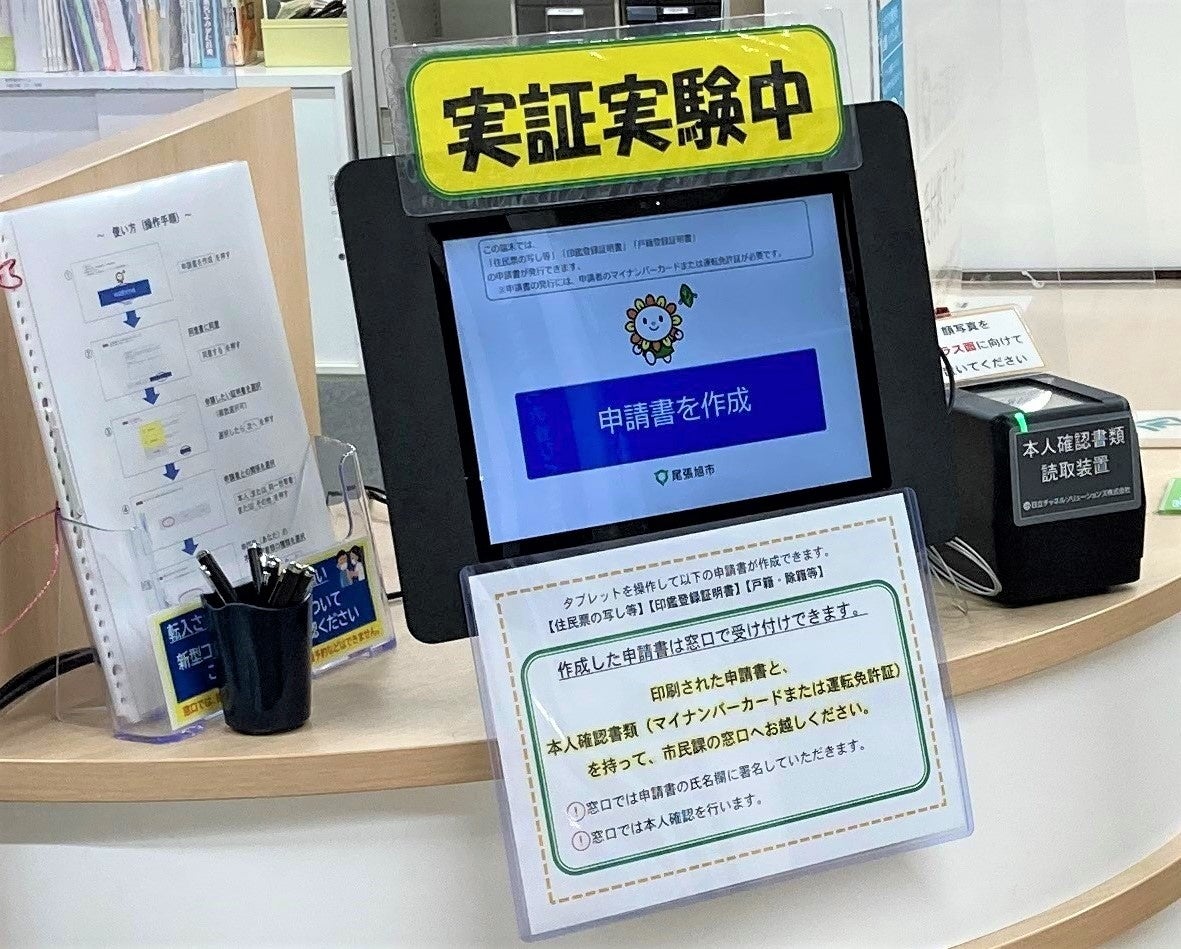 尾張旭市役所窓口で開始した実証実験 (写真はタブレット端末と本人確認書類読取装置)