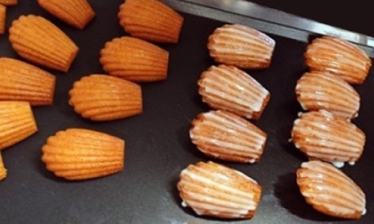 焼きあがったマドレーヌにレモン果汁入り砂糖をコーティング