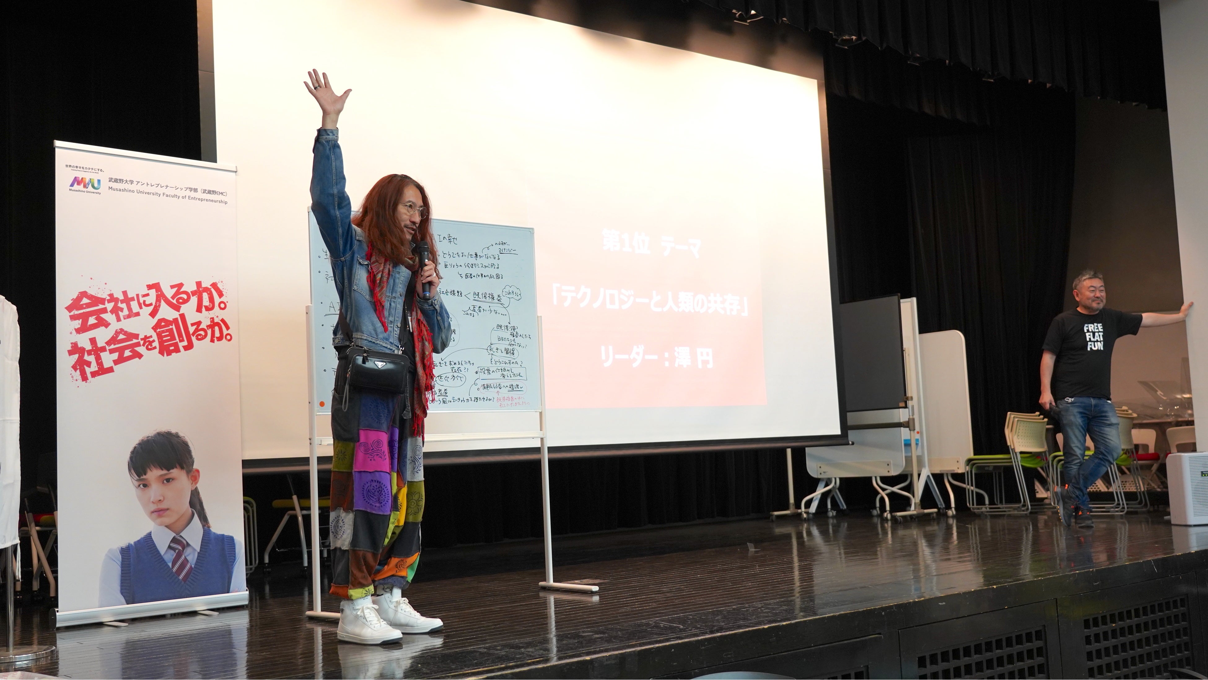 壇上で「テクノロジーと人類の共存」の社会課題について 実践者に訴えている澤教授の様子