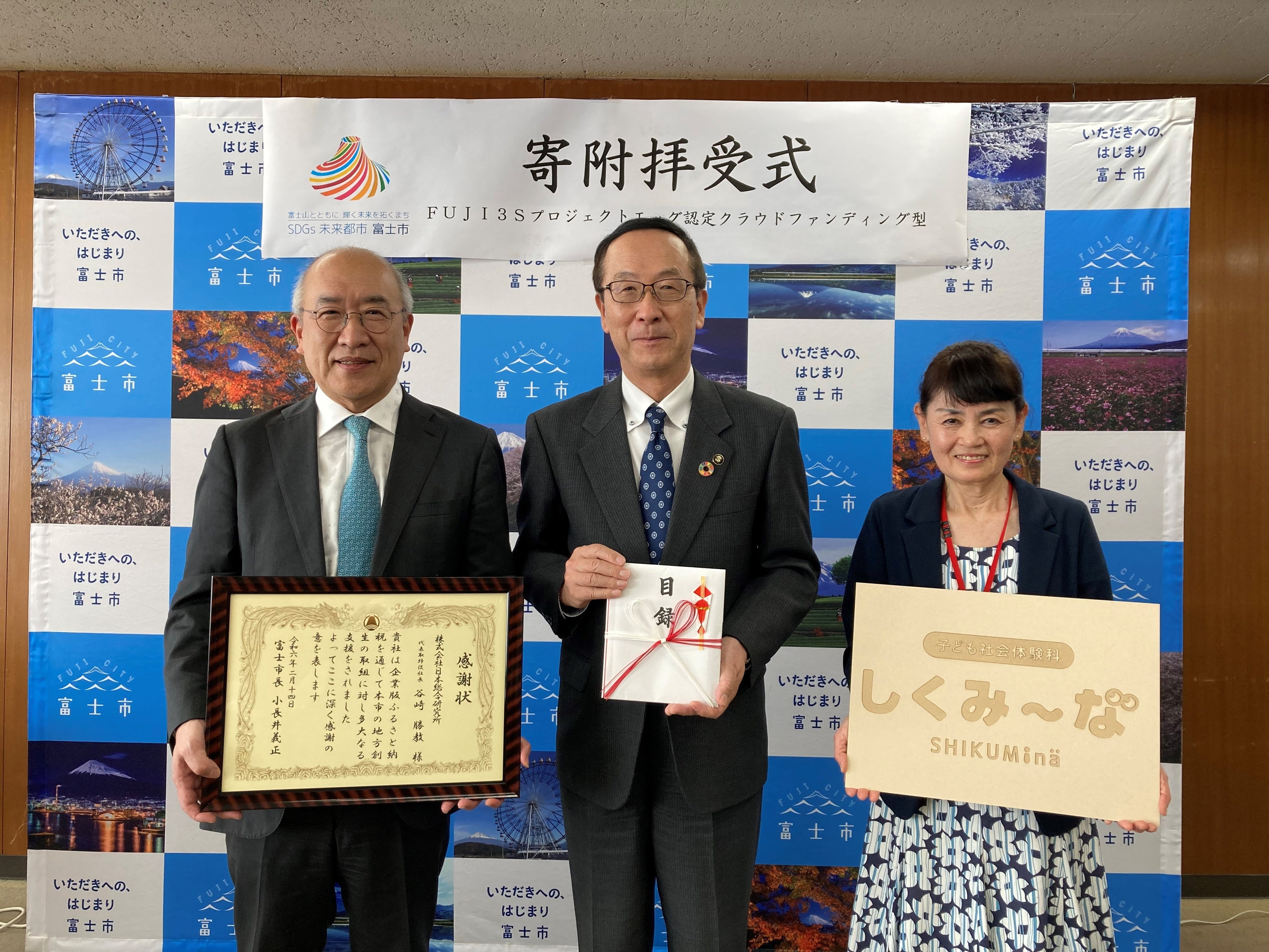 贈呈式の様子　　左から、日本総研 谷崎社長、富士市 小長井市長、まちの遊民社 篠原代表理事