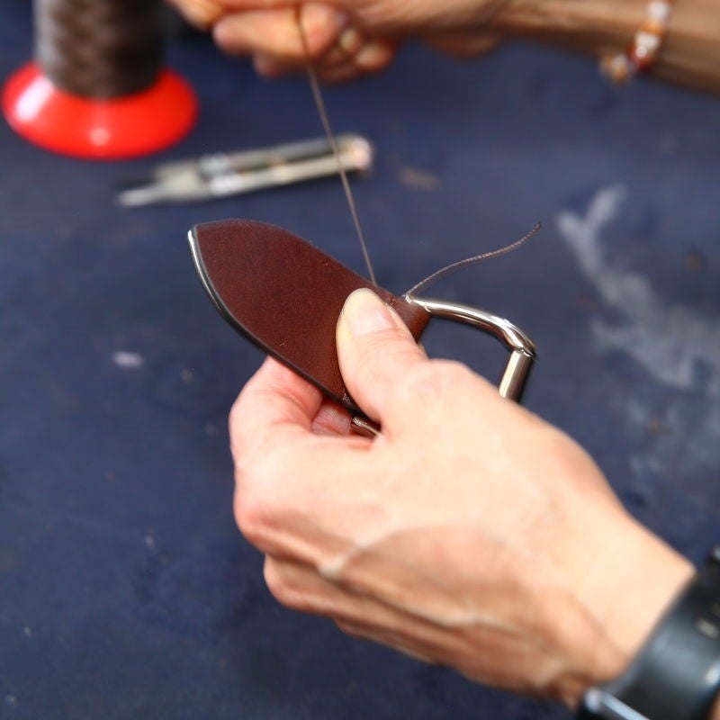 根革部分は手縫いで糸を一本ずつ通して製作