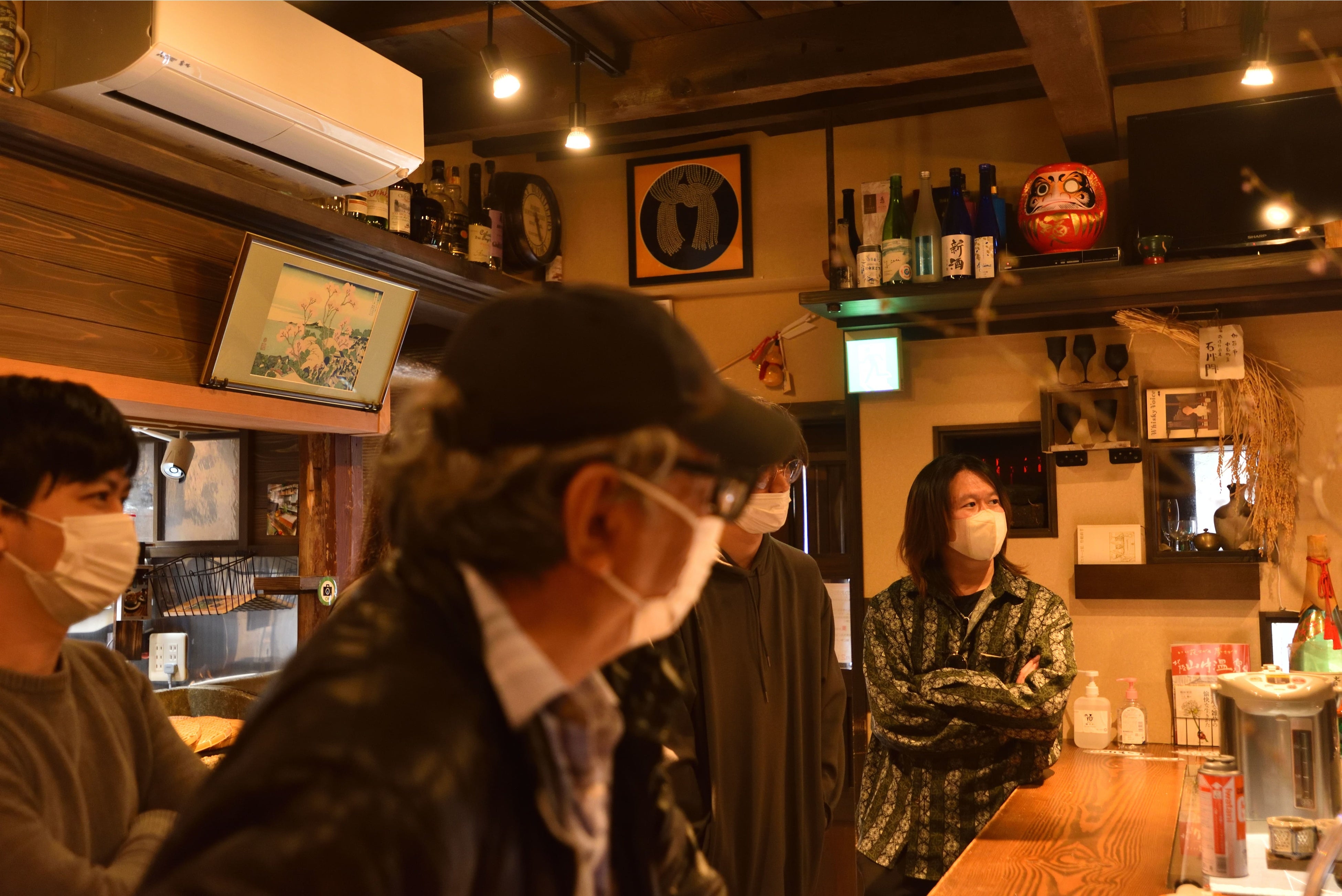 地域住民の方の話を聞く、カガリべ利用者の皆さんとガイドの佐竹