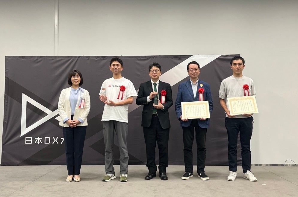 授賞式の様子(DNP社員の尾野さん：上の写真の左から3番目、下の写真の右から1番目）)