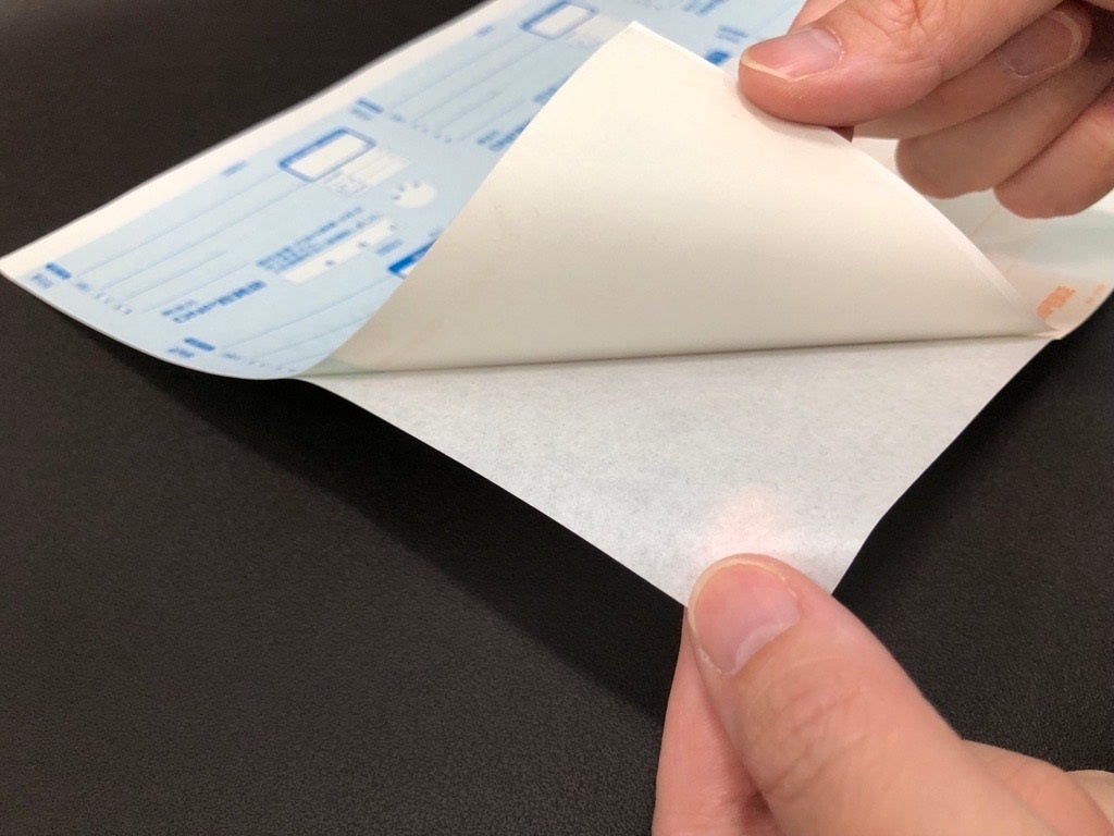 「ラベル伝票」から剥離紙をはがすイメージ