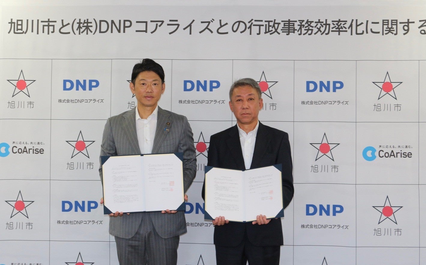 協定報告会に出席した旭川市長 今津寛介（左）と、DNPコアライズ代表取締役 斎藤友紀雄（右）