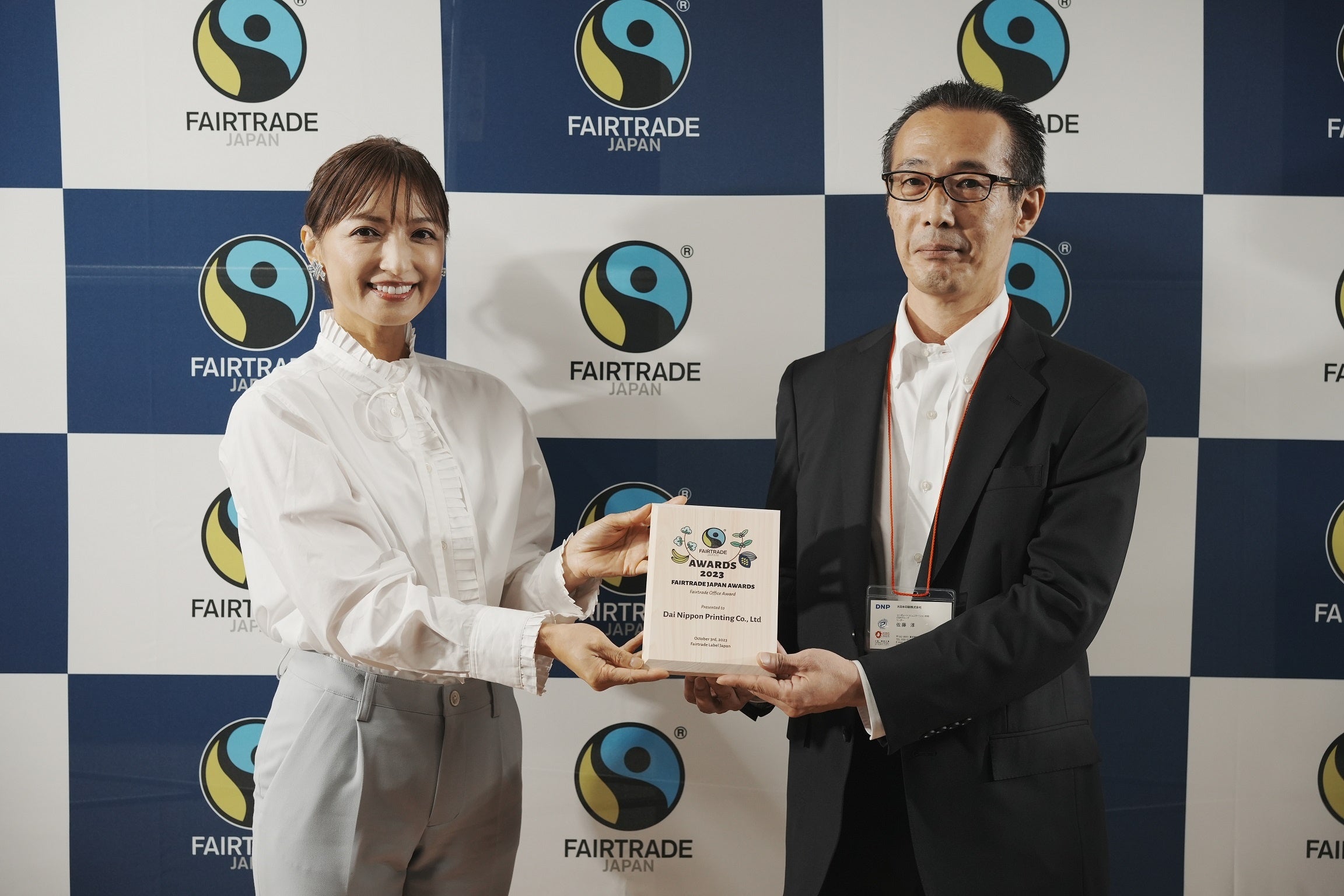 受賞式の様子（左：プレゼンターの望月理恵アナウンサー、 右：DNPの佐藤淳CSRグループリーダー）