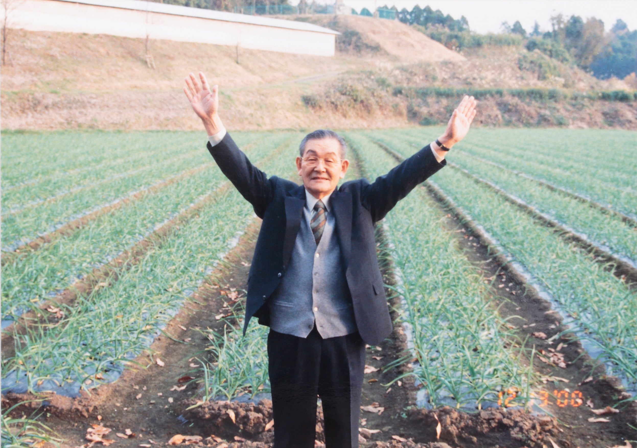 ▲健康家族の創業者・本多荘輔とにんにく畑