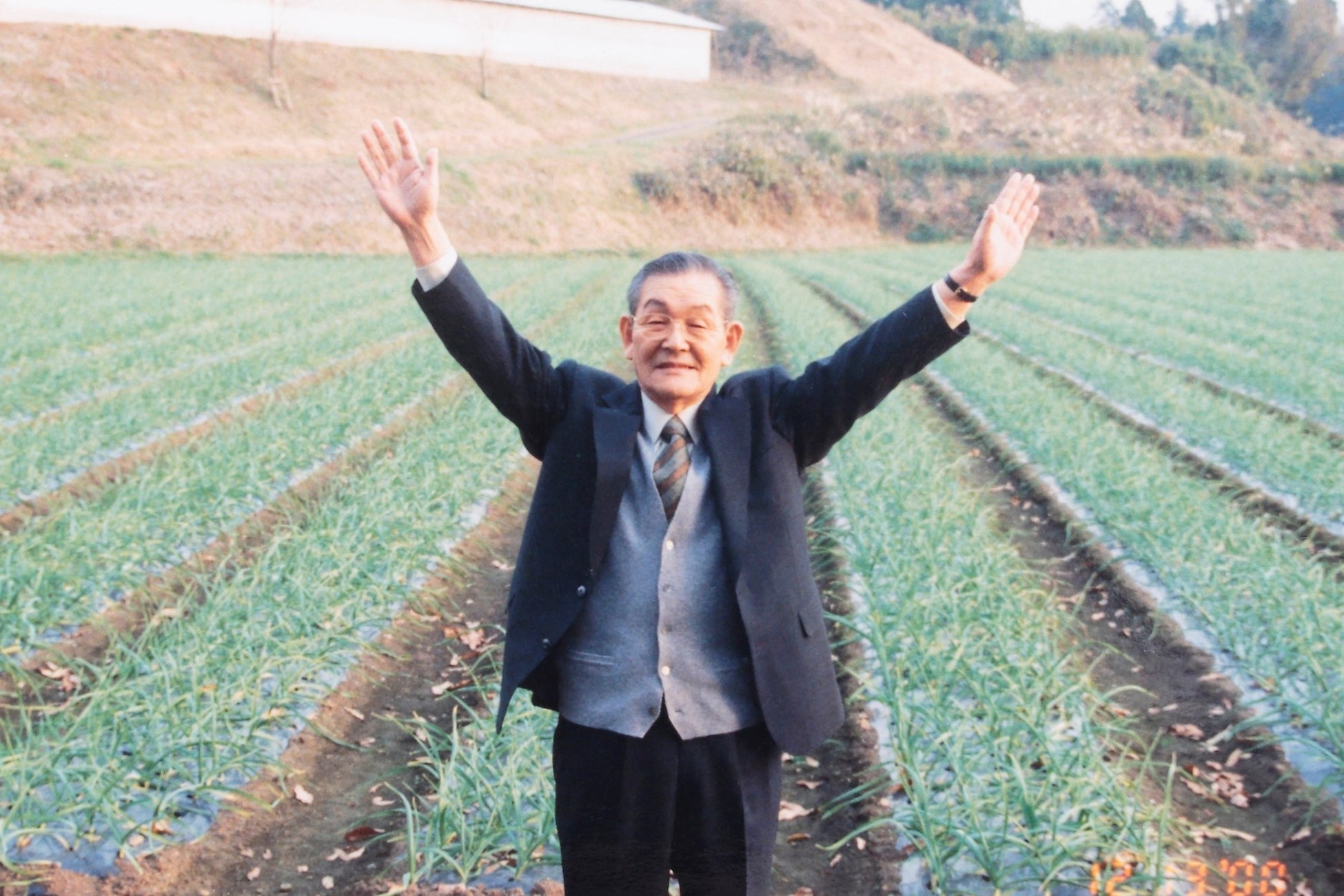 ▲にんにく畑の前に立つ創業者・本多荘輔