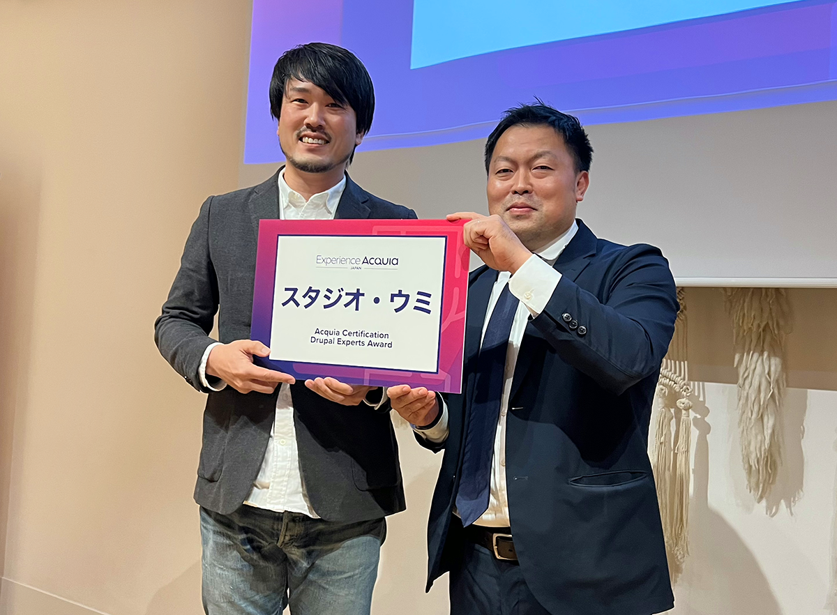 アクイアジャパン カントリーマネージャー 小坂氏（右）よりパネルを授与されるスタジオ・ウミ事業部長 大野（左）