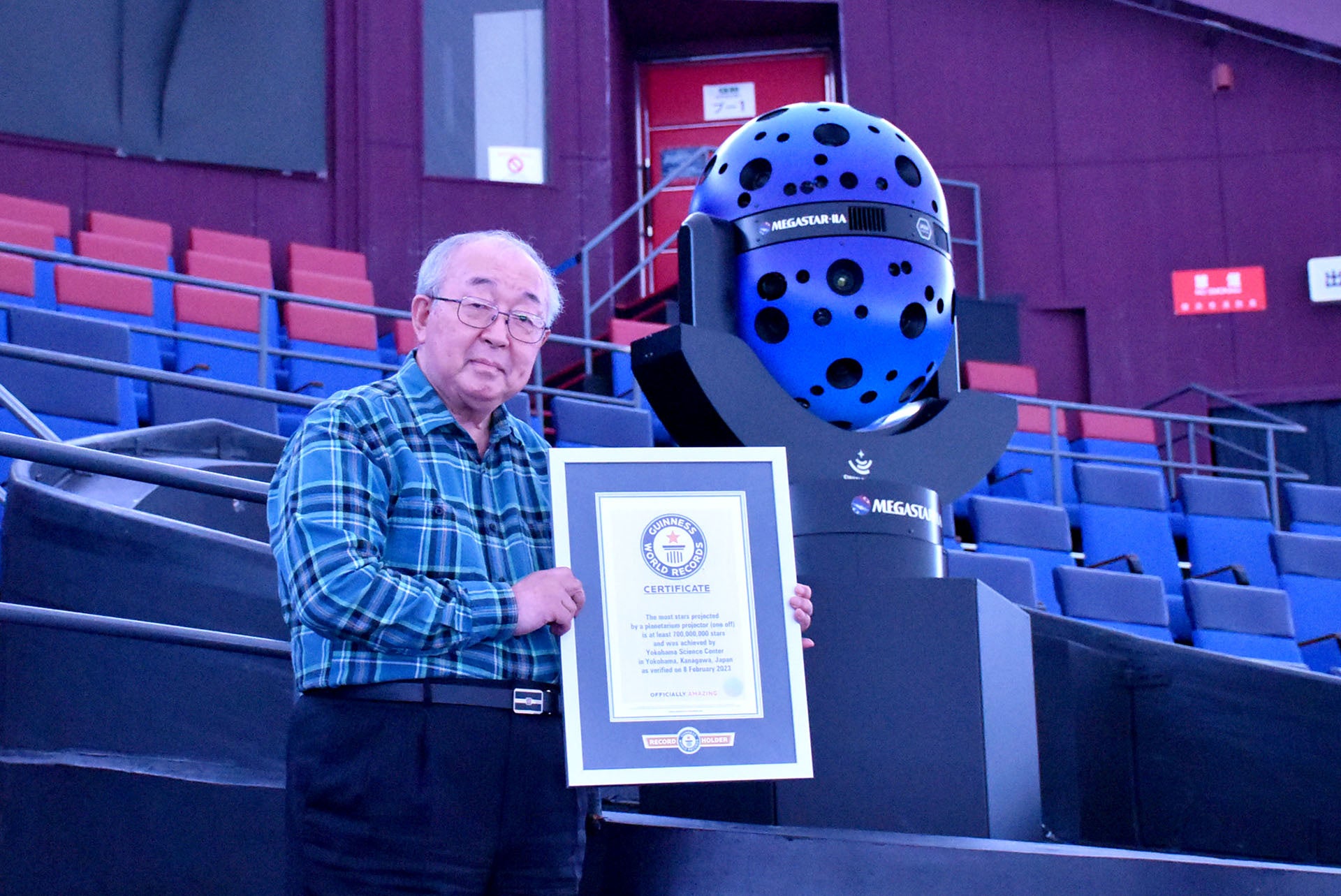 （写真）プラネタリウム投影機「MEGASTAR-IIA」と的川泰宣館長（はまぎん こども宇宙科学館 館長、JAXA名誉教授）