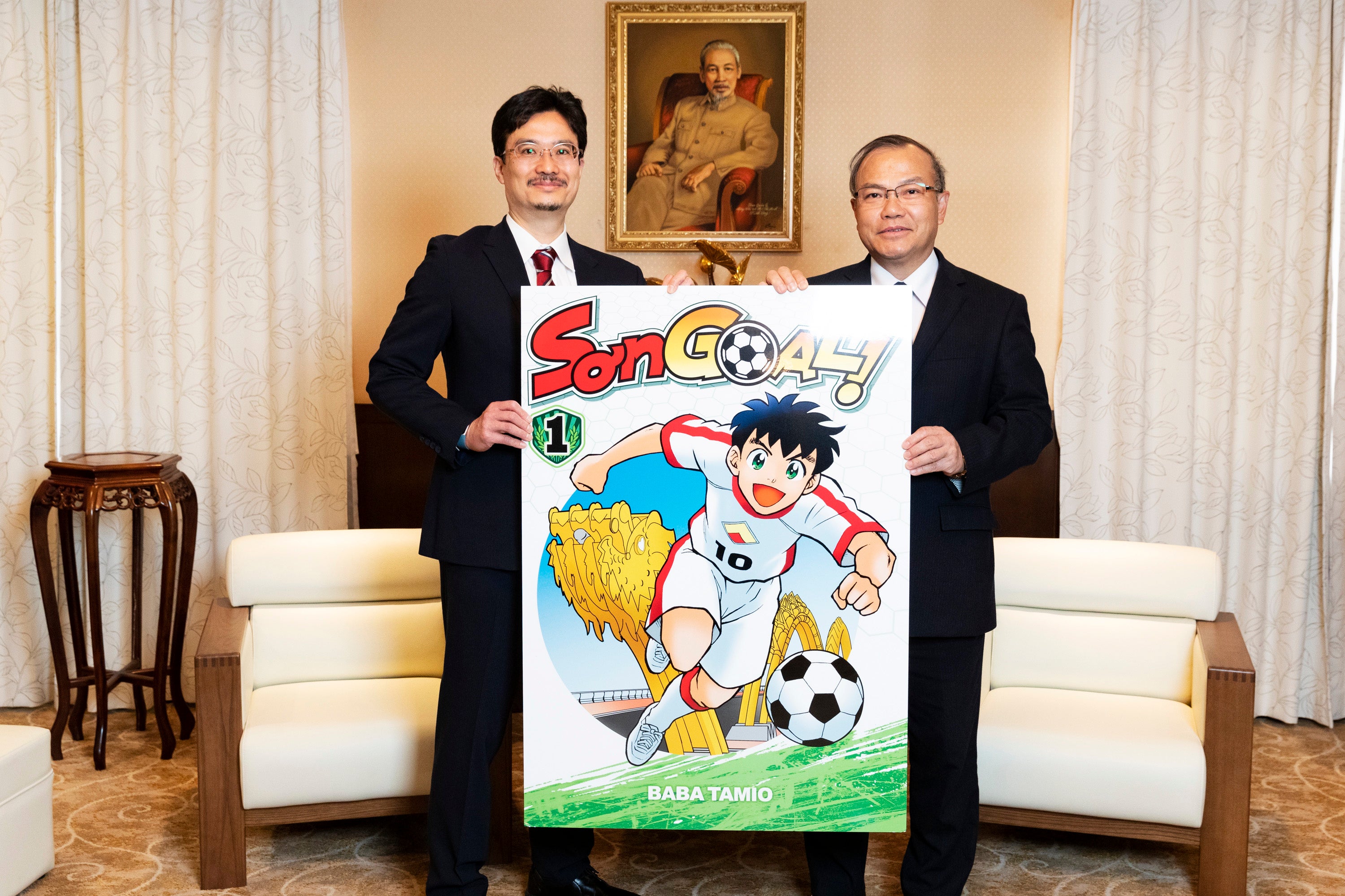 ベトナムで刊行予定のマンガ『SON GOAL！（ソン ゴール！）』（馬場民雄／著）1巻のパネルを手に、ヴー・ホン・ナム駐日ベトナム社会主義共和国特命全権大使（右）とＫＡＤＯＫＡＷＡ青柳昌行ＣＰＯ（左）による記念撮影。（撮影：野口彈）
