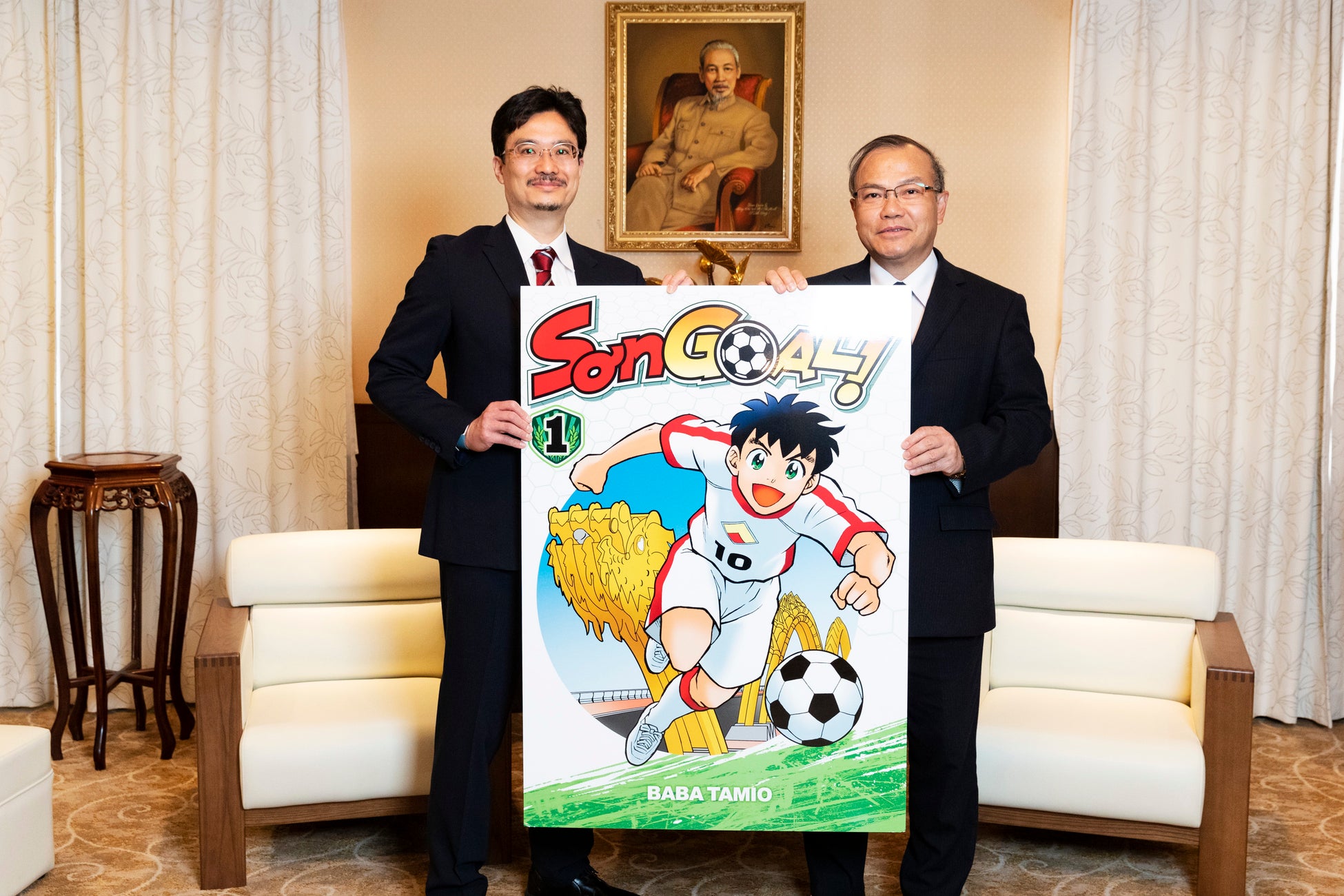 ベトナムで刊行予定のマンガ『SON GOAL!(ソン ゴール!)』(馬場民雄/著)1巻のパネルを手に、ヴー・ホン・ナム駐日ベトナム社会主義共和国特命全権大使(右)とKADOKAWA青柳昌行CPO(左)による記念撮影。(撮影:野口彈)