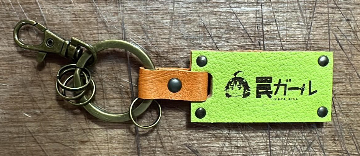 『罠ガール』のロゴとイラストが入った特製レザーキーホルダー