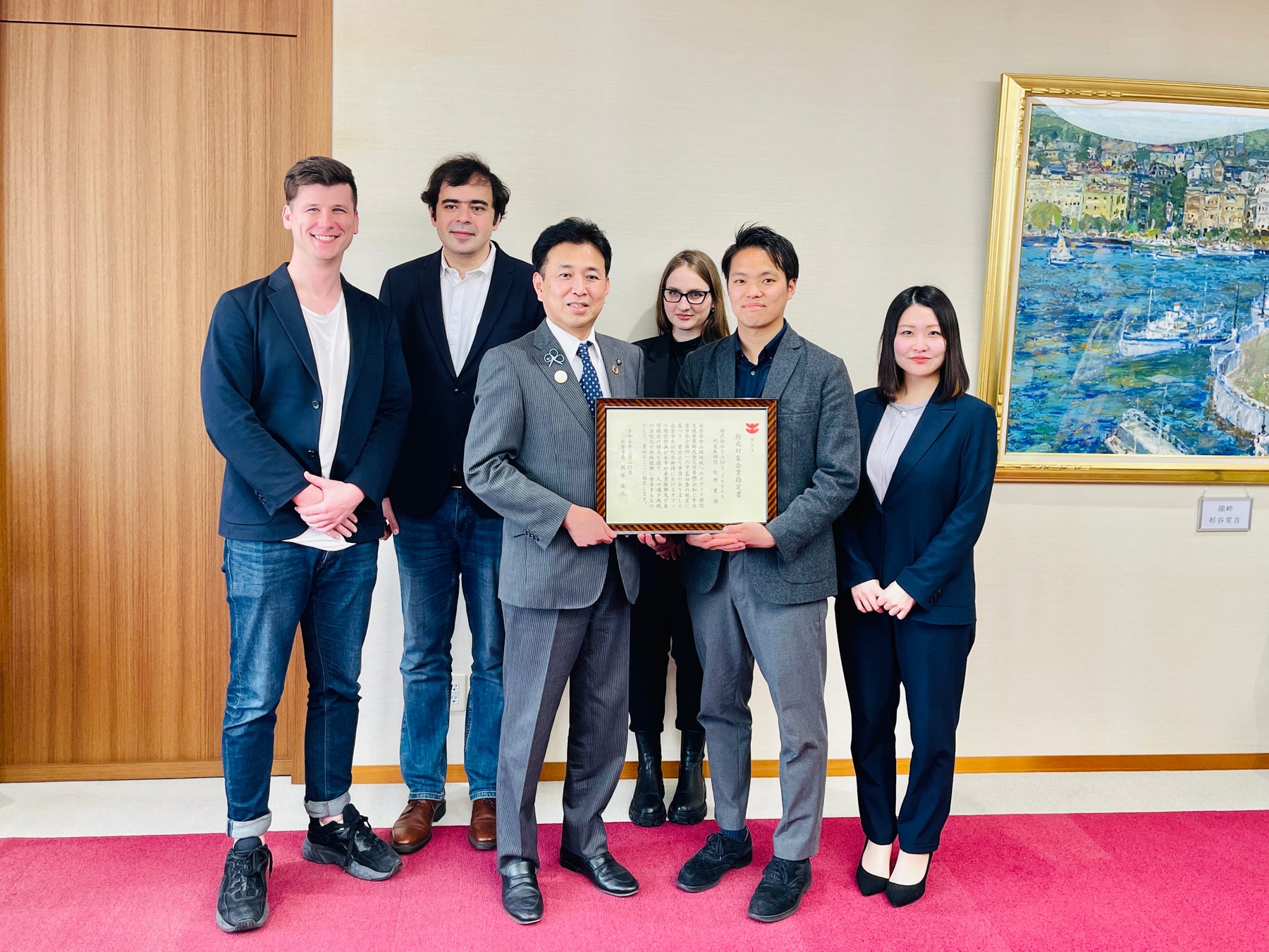 出雲市役所で行われた「助成対象企業指定書」交付式での出雲市の飯塚俊之市長とSAMIメンバー