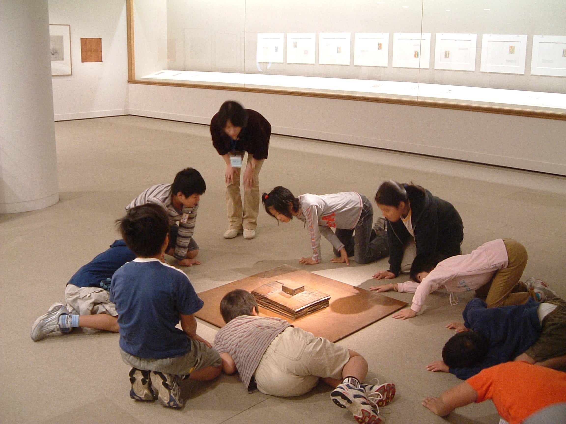 作品を見るボランティアと子どもたち