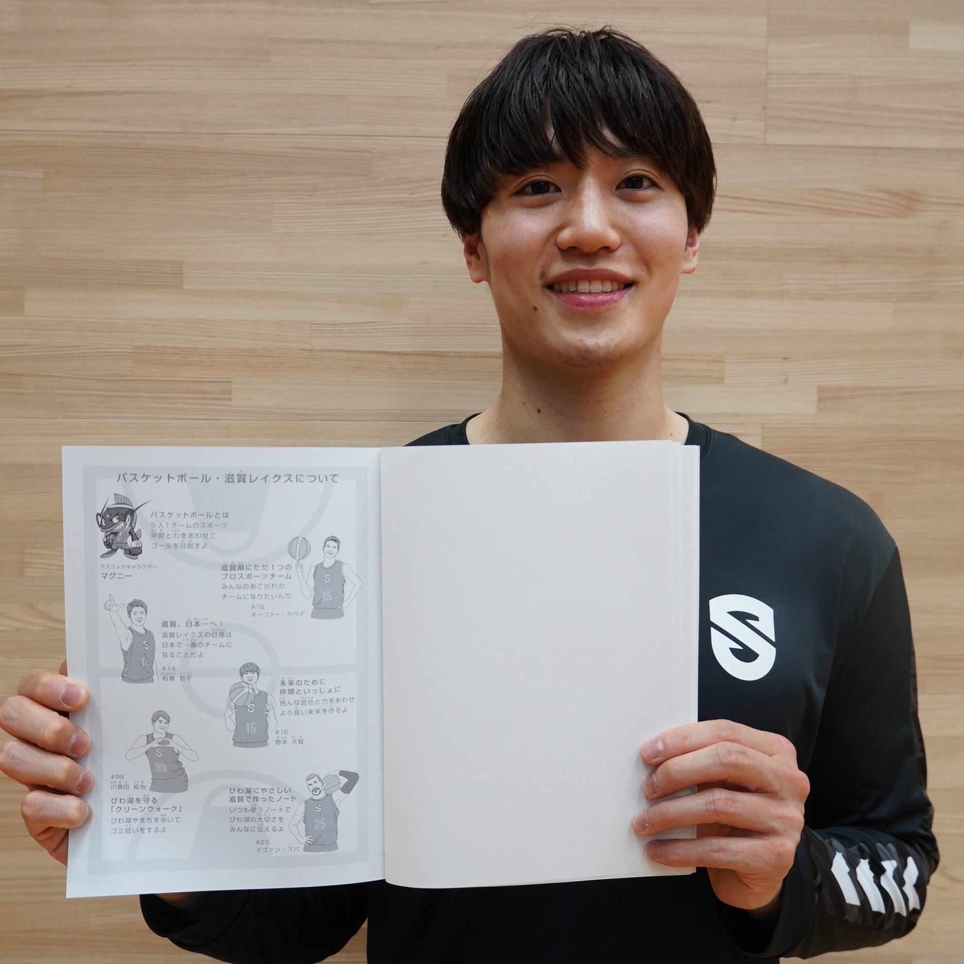 滋賀県の小学生に寄贈されるノートを手にする野本大智選手