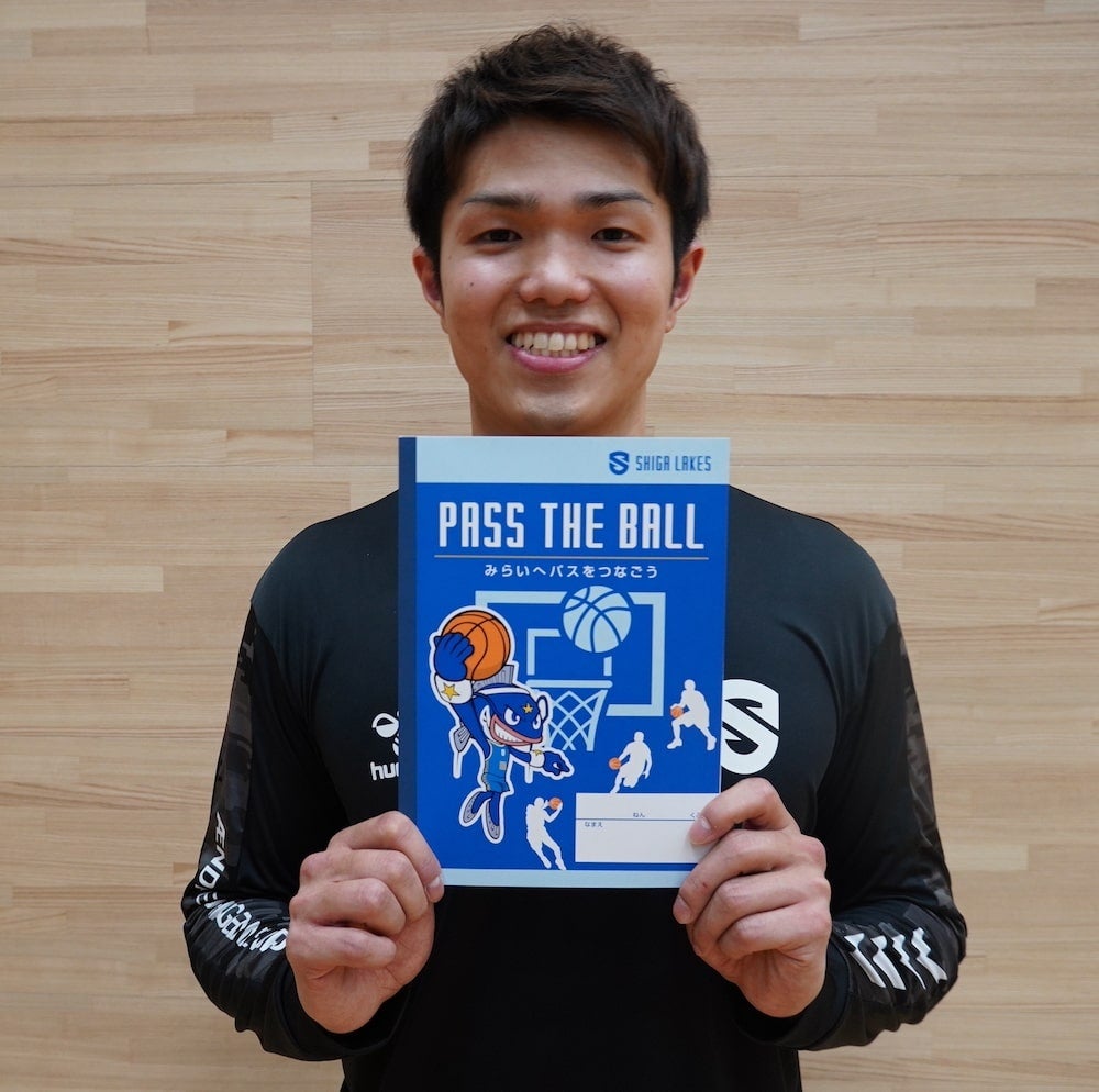 滋賀県の小学生に寄贈されるノートを手にする柏倉哲平選手