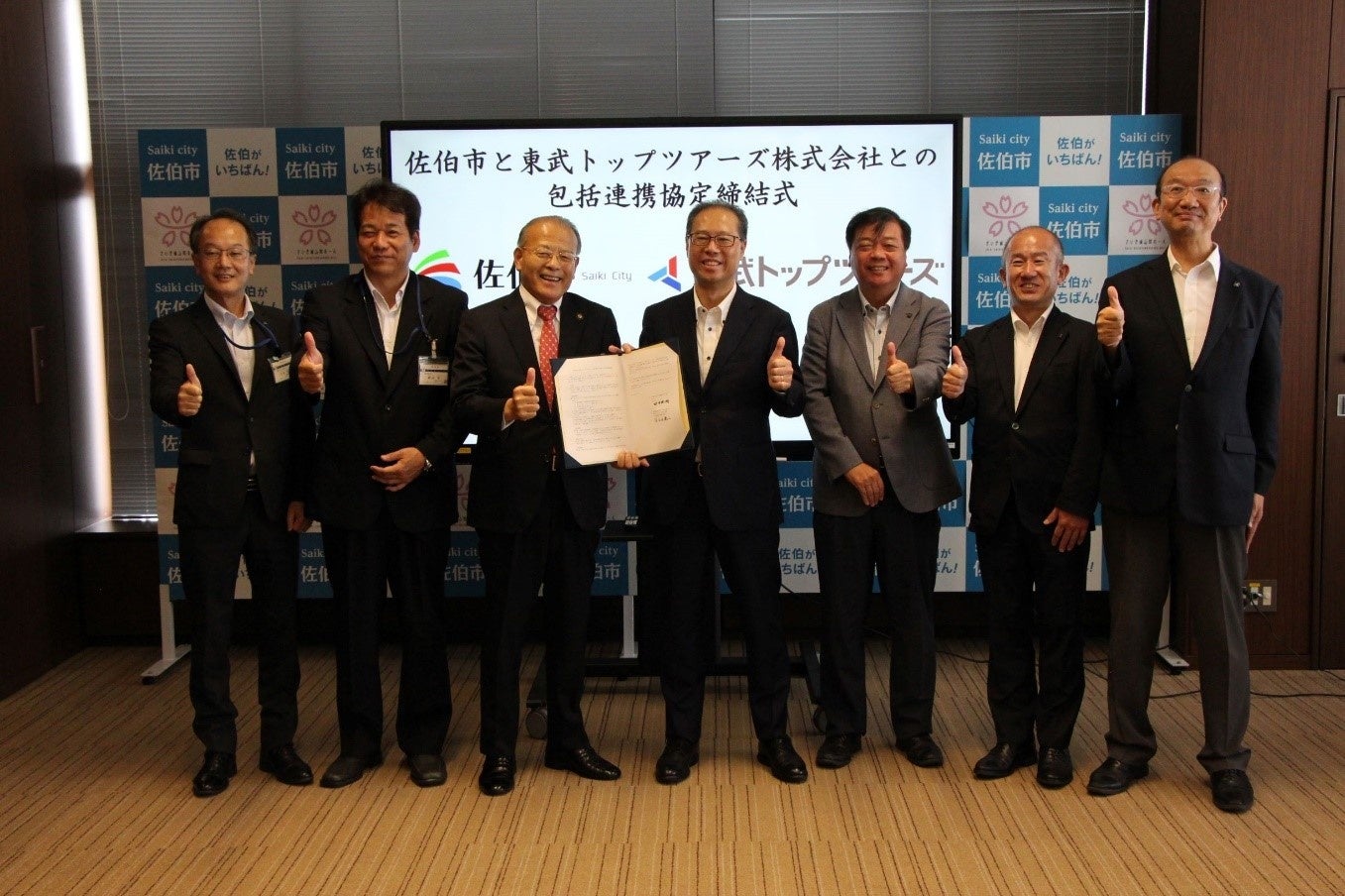 8／7包括連携協定締結式の様子（写真 左より3人目　田中利明市長 ／ 右より4人目　百木田康二代表取締役社長）