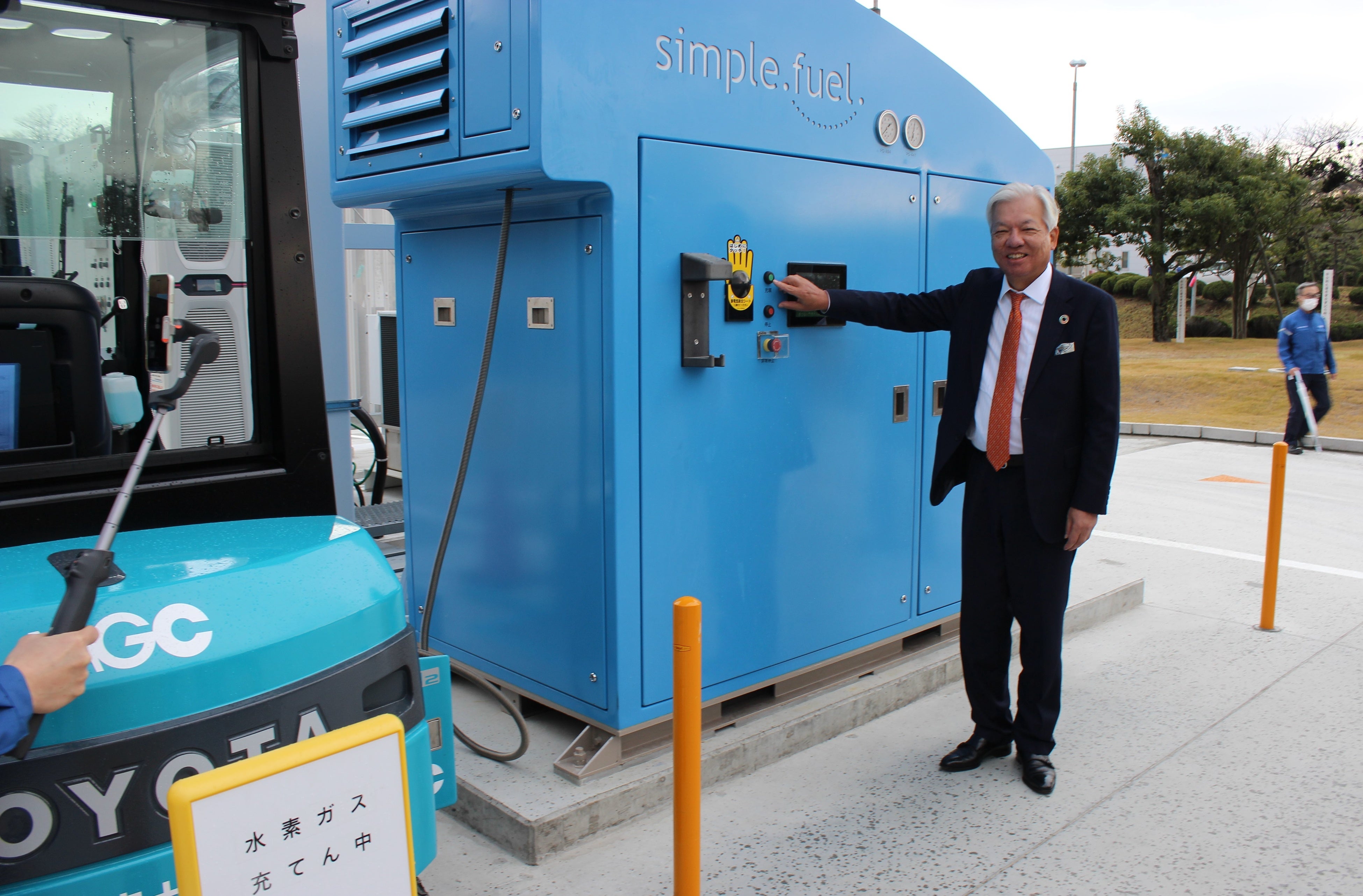 充填中（写真中央：三菱ガス化学 藤井社長）出典：三菱ガス化学