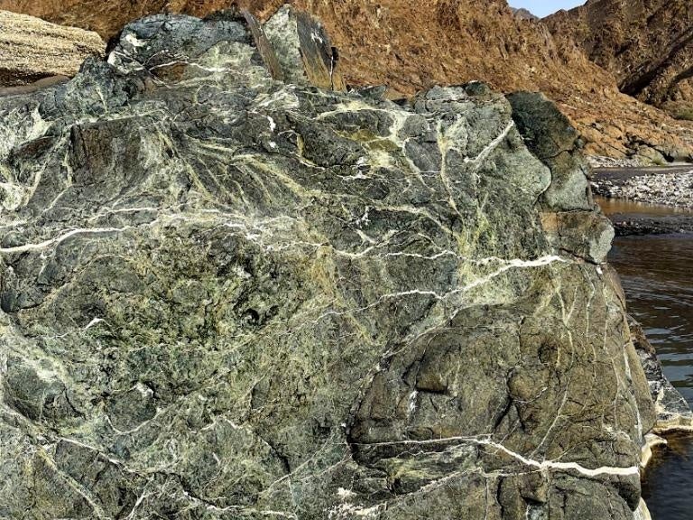 かんらん岩と反応したCO2が鉱物化し、白い帯のように見える