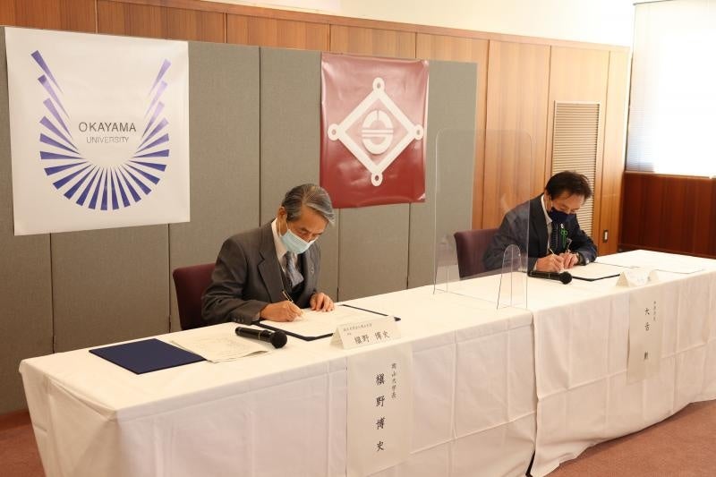 協定書に署名する槇野学長(左)と大舌市長