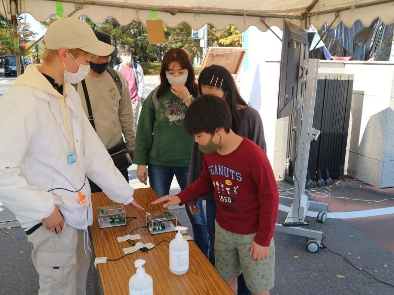 装置に手をかざす入場者