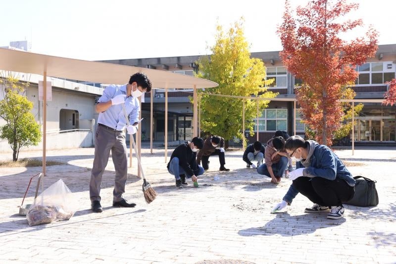 学生・教職員が協力して草刈りを行う様子