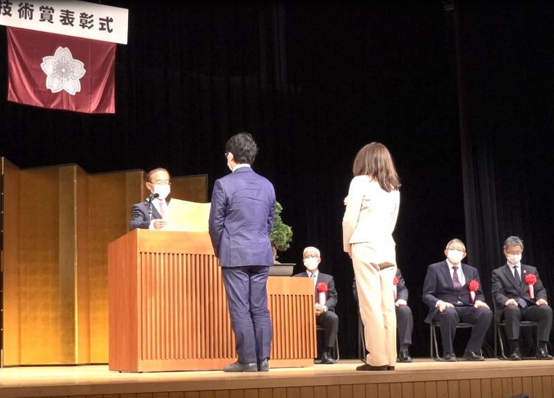 前田消防庁長官から表彰状を受け取る塚原助教